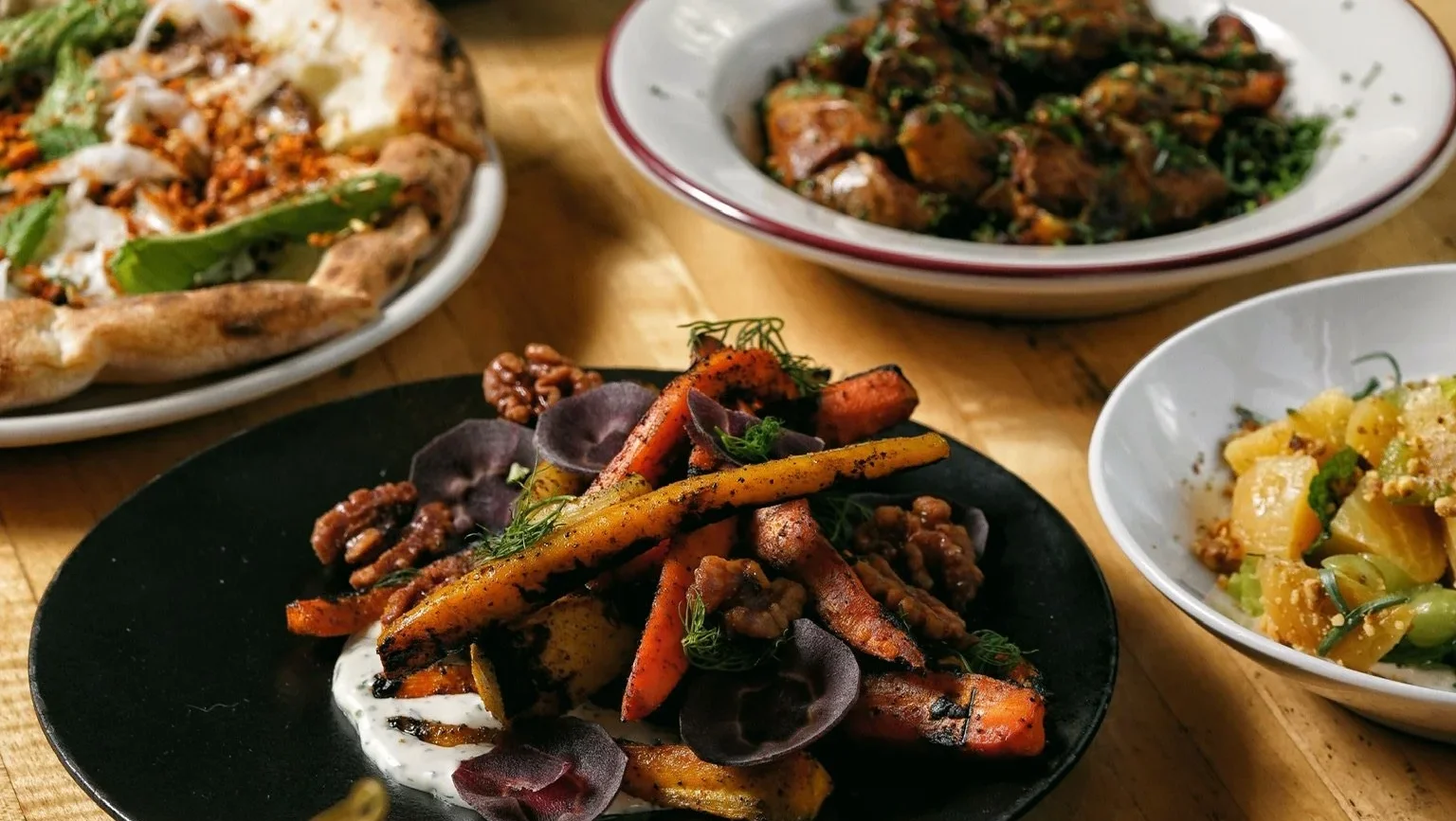 Delicious gourmet dishes with fresh toppings on a wooden table