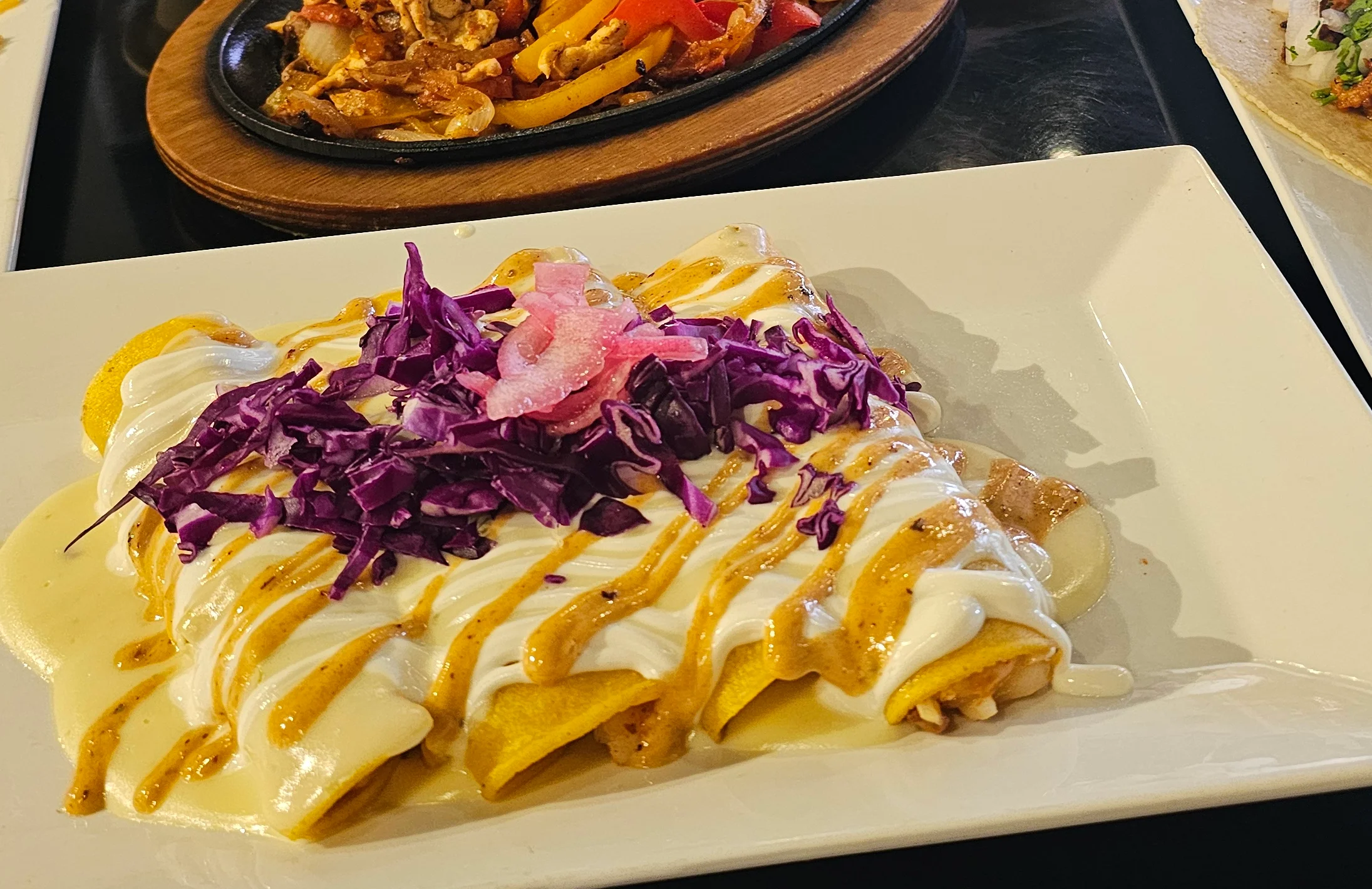 Colorful Mexican platter with enchiladas, tacos, and sizzling fajitas