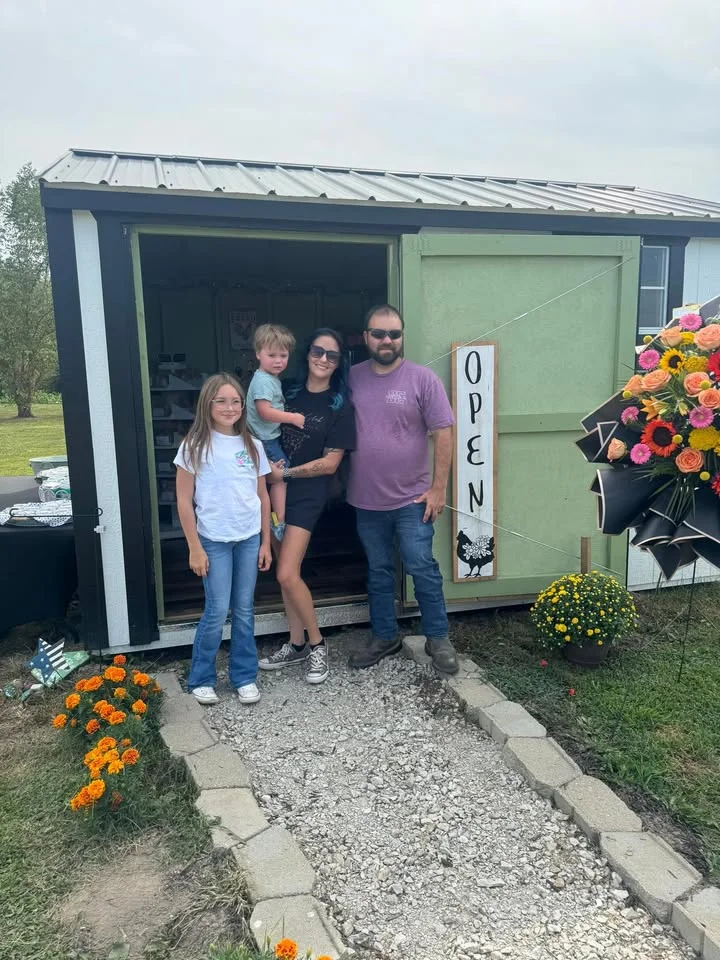 Family outside a charming open shop with flowers and welcoming signage