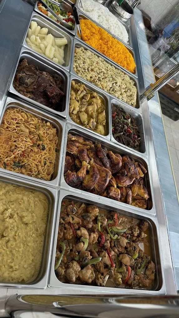 Assorted West African buffet with rice, chicken, and noodles