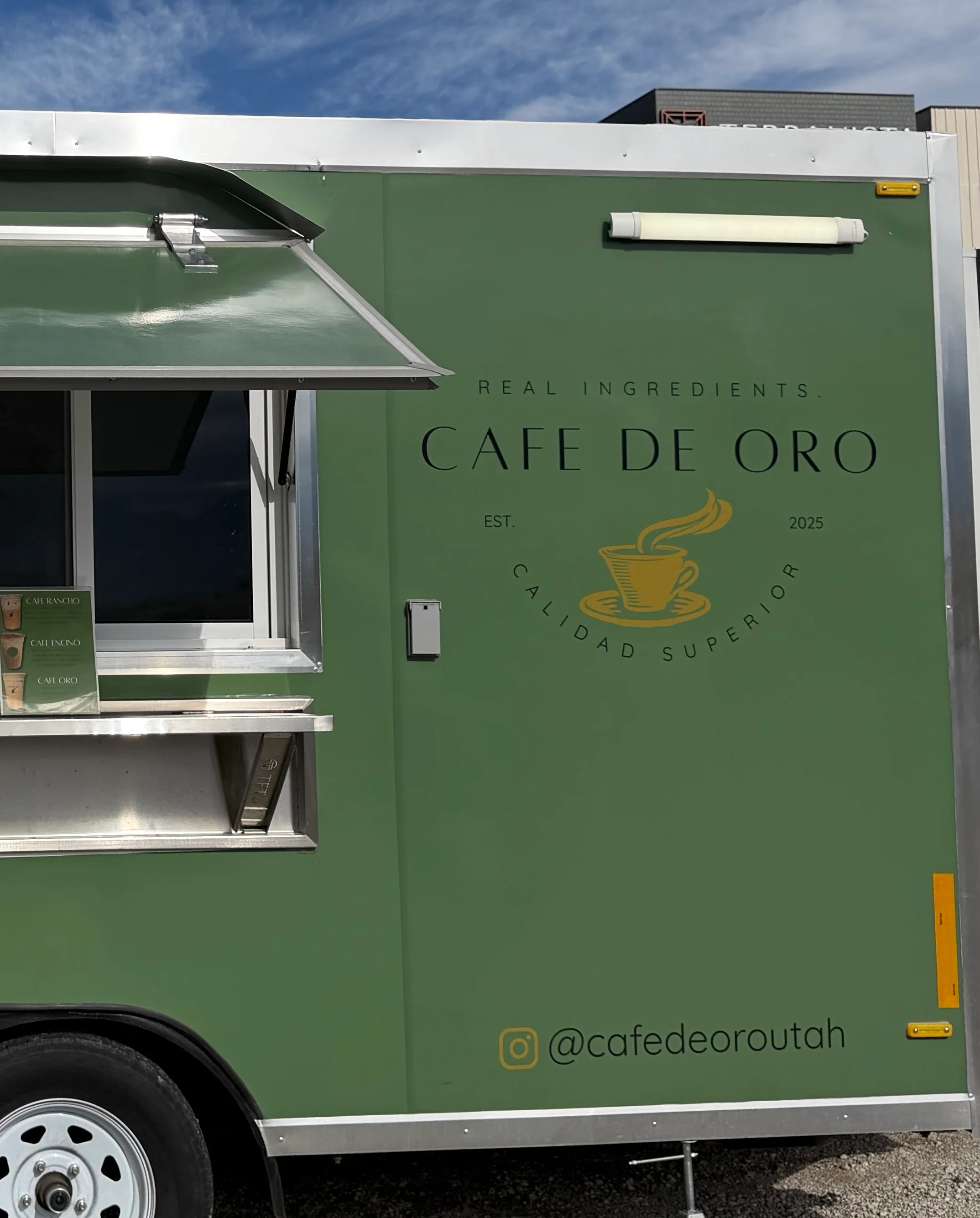 Logo of Cafe de Oro established in 2025 with a coffee cup illustration