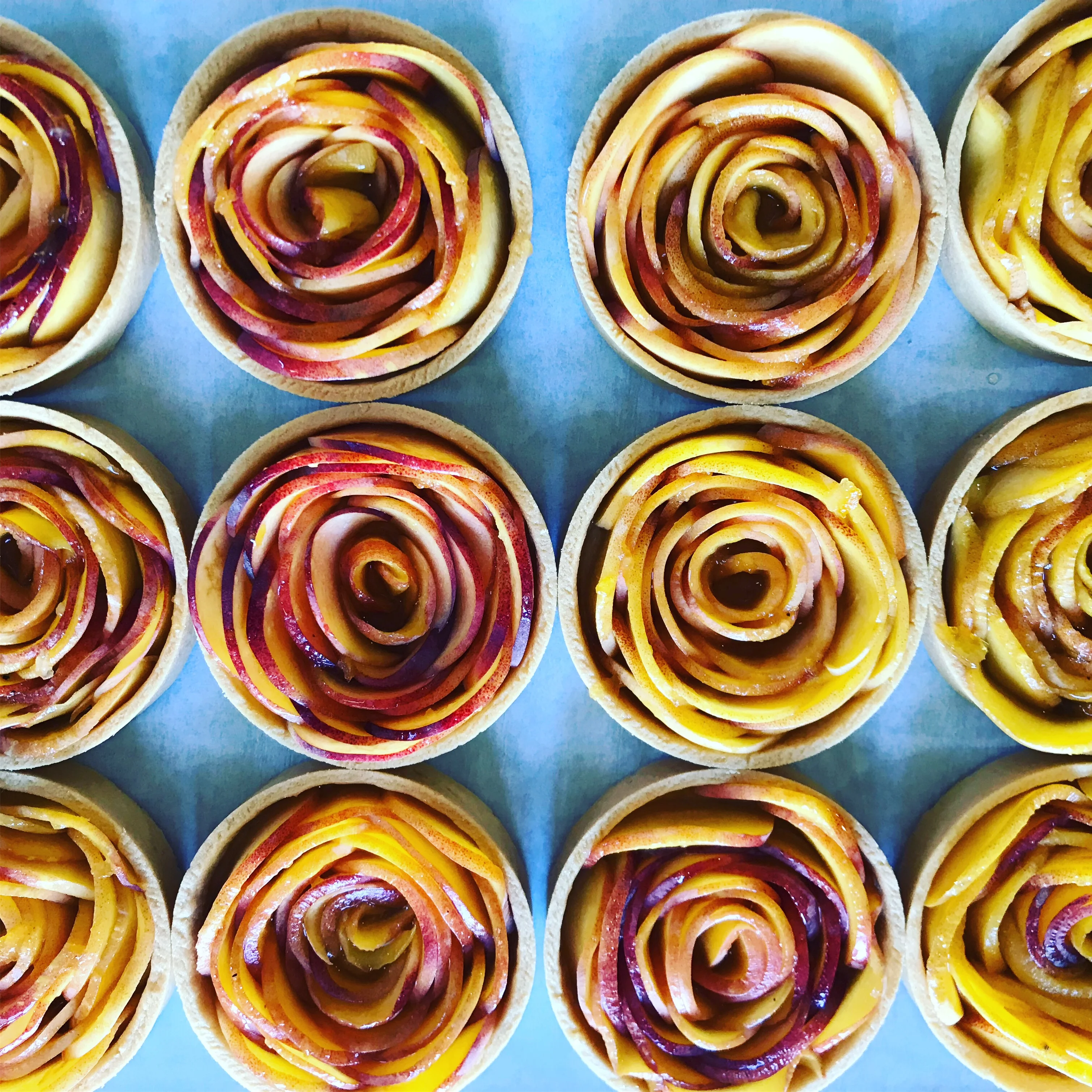 Elegant apple rose tarts arranged in a circular pattern