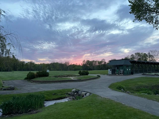 Scenic sunset over a golf course with lush greenery