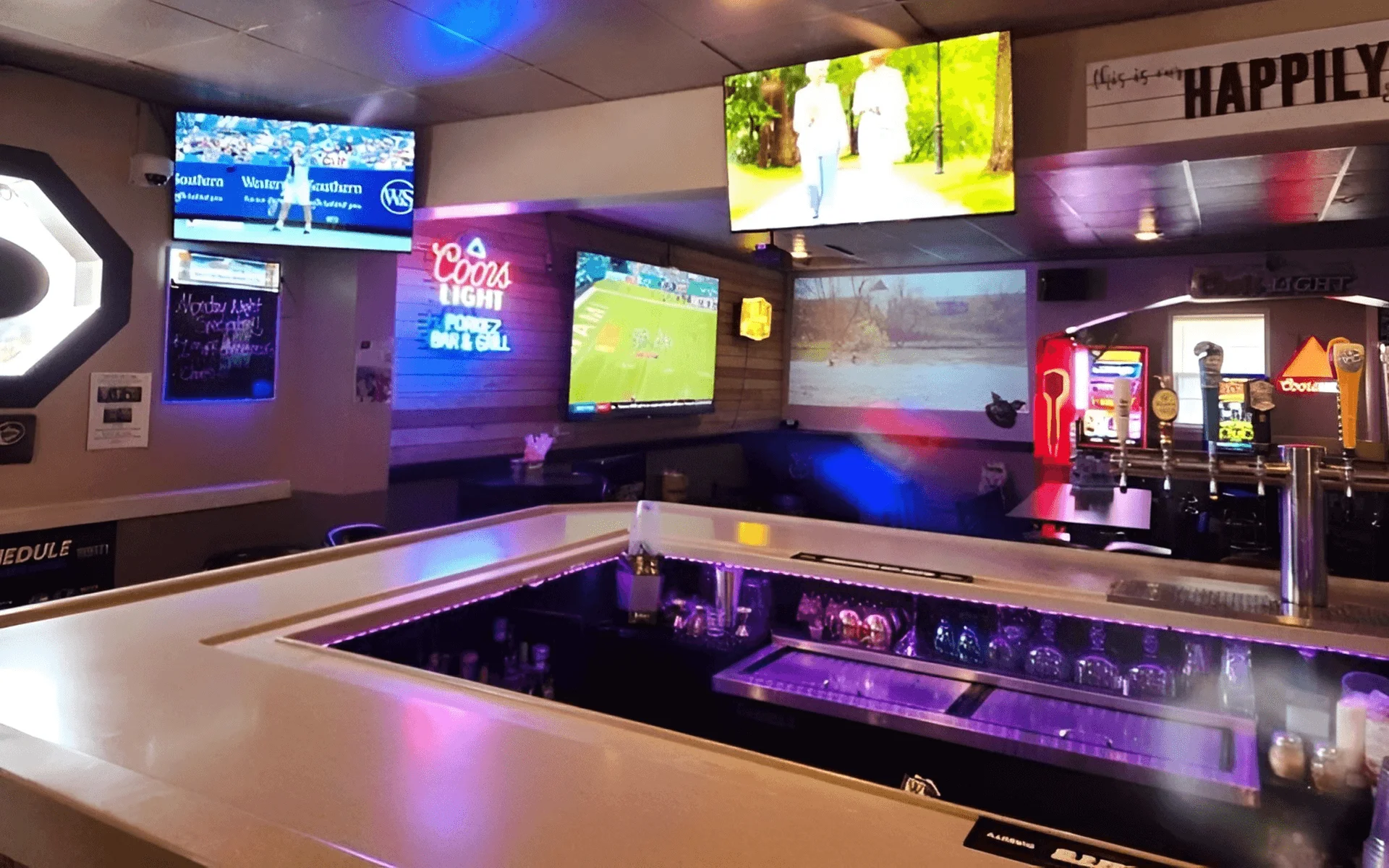 Modern bar interior with multiple screens and vibrant lighting