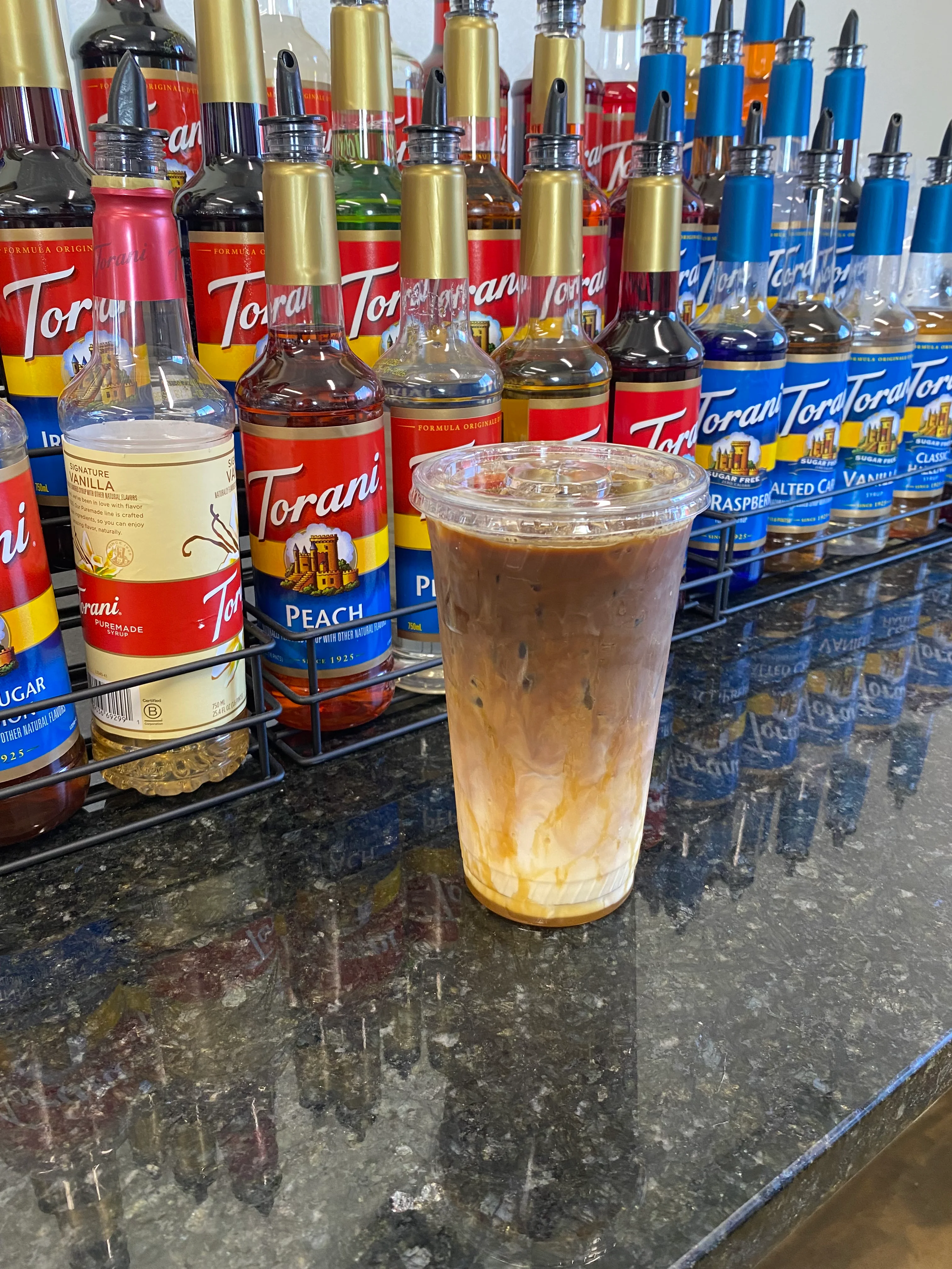 Iced coffee drink with flavored syrups at a café counter
