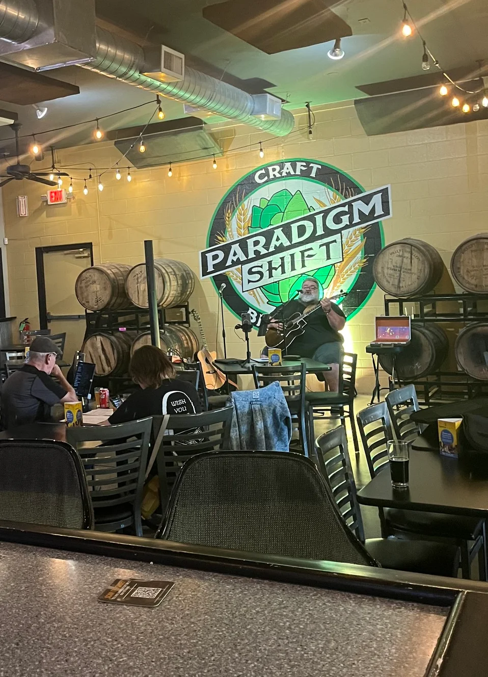 A lively open mic night at a restaurant with performers and an engaged audience.