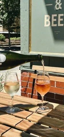 Pouring sparkling wine into glasses on a sunny patio