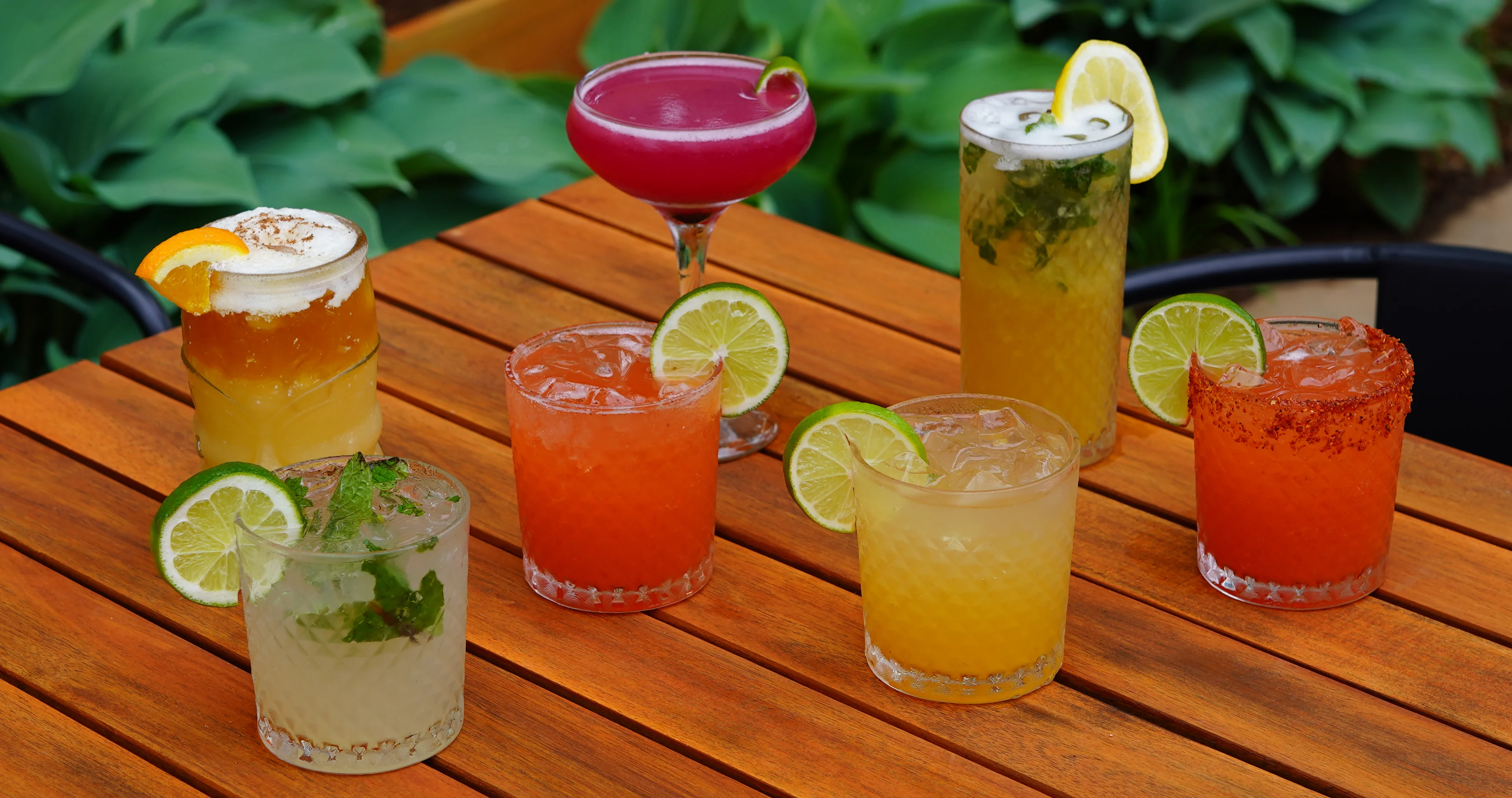 Colorful cocktails on a wooden table in a vibrant outdoor setting