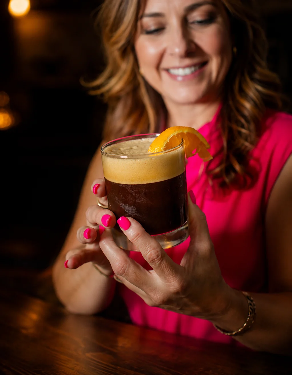 Bartender pouring a cocktail into a glass at a stylish bar