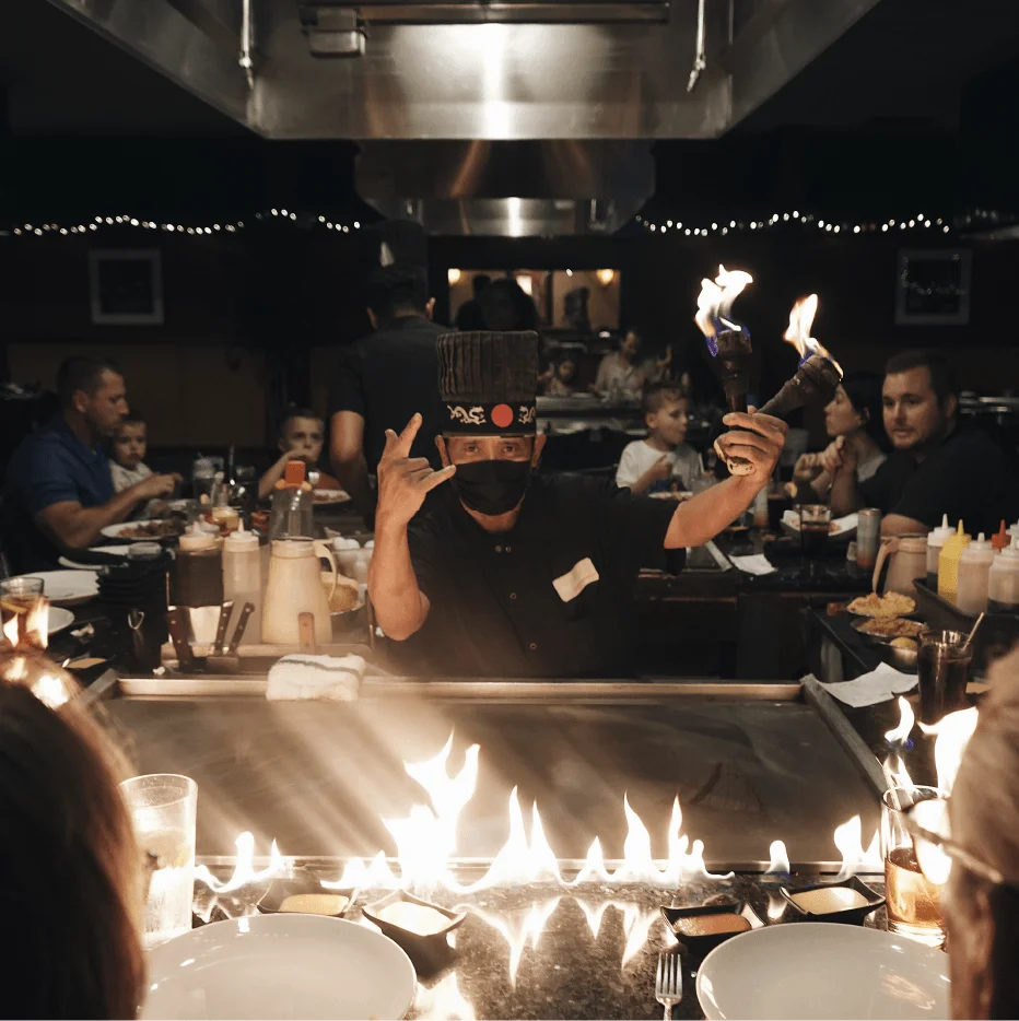 Hibachi chef juggling flaming torches for a celebration table at Mahzu East Windsor