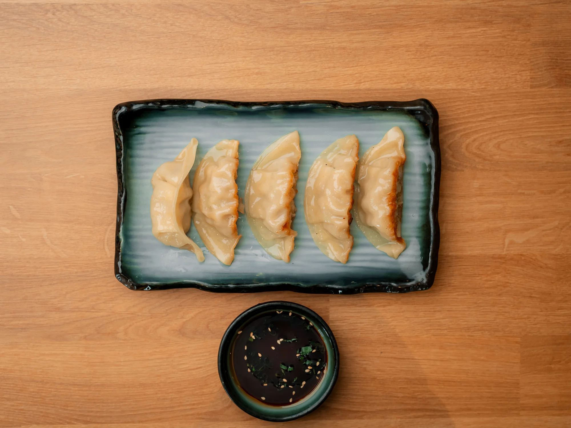 Plate of Japanese gyoza dumplings with dipping sauce