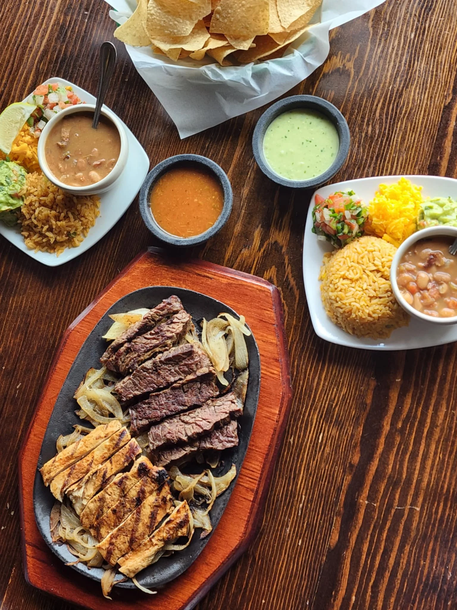 Sizzling fajitas with grilled chicken and beef served with sides