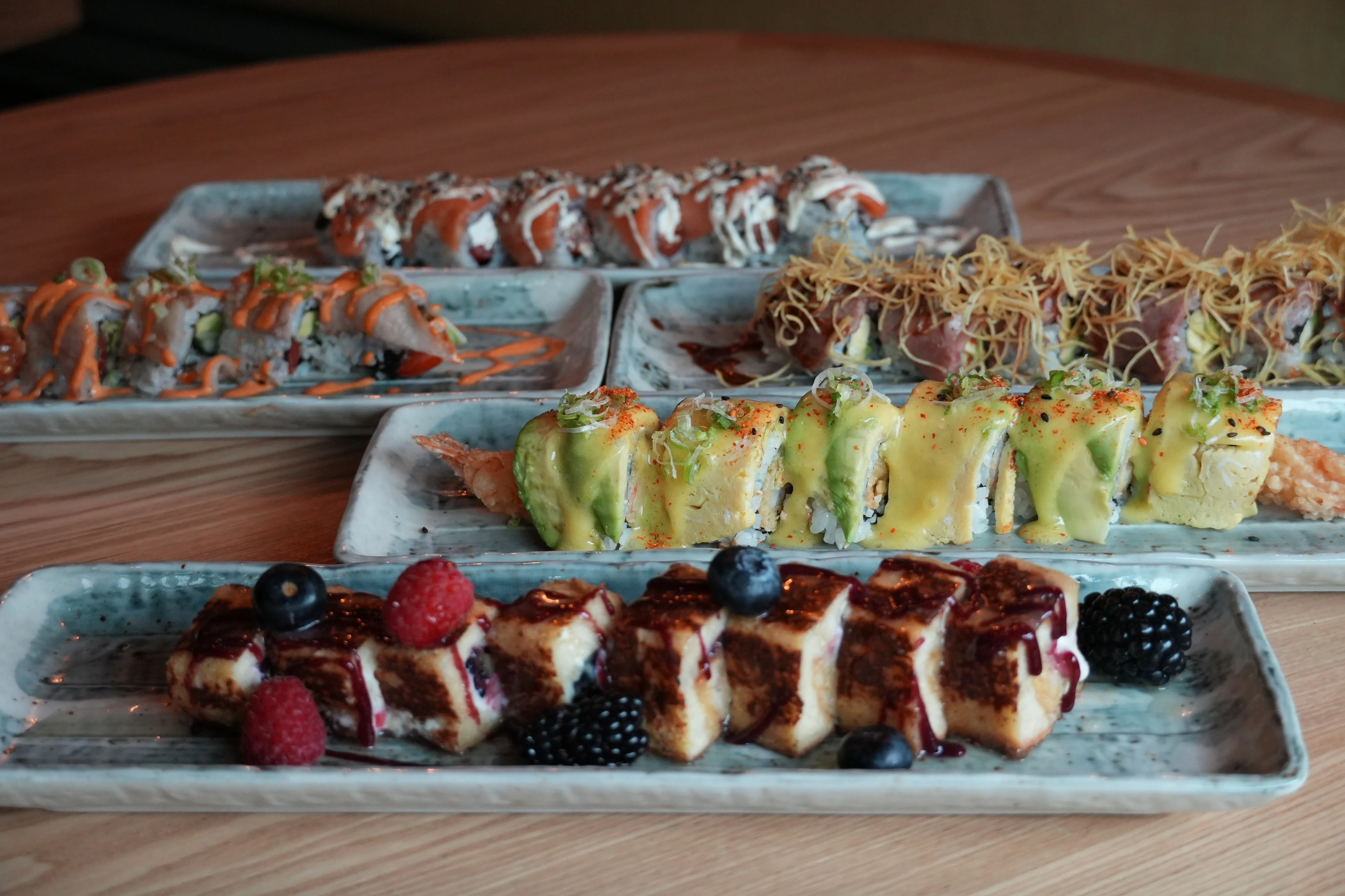 Assorted sushi rolls and dessert served on elegant plates