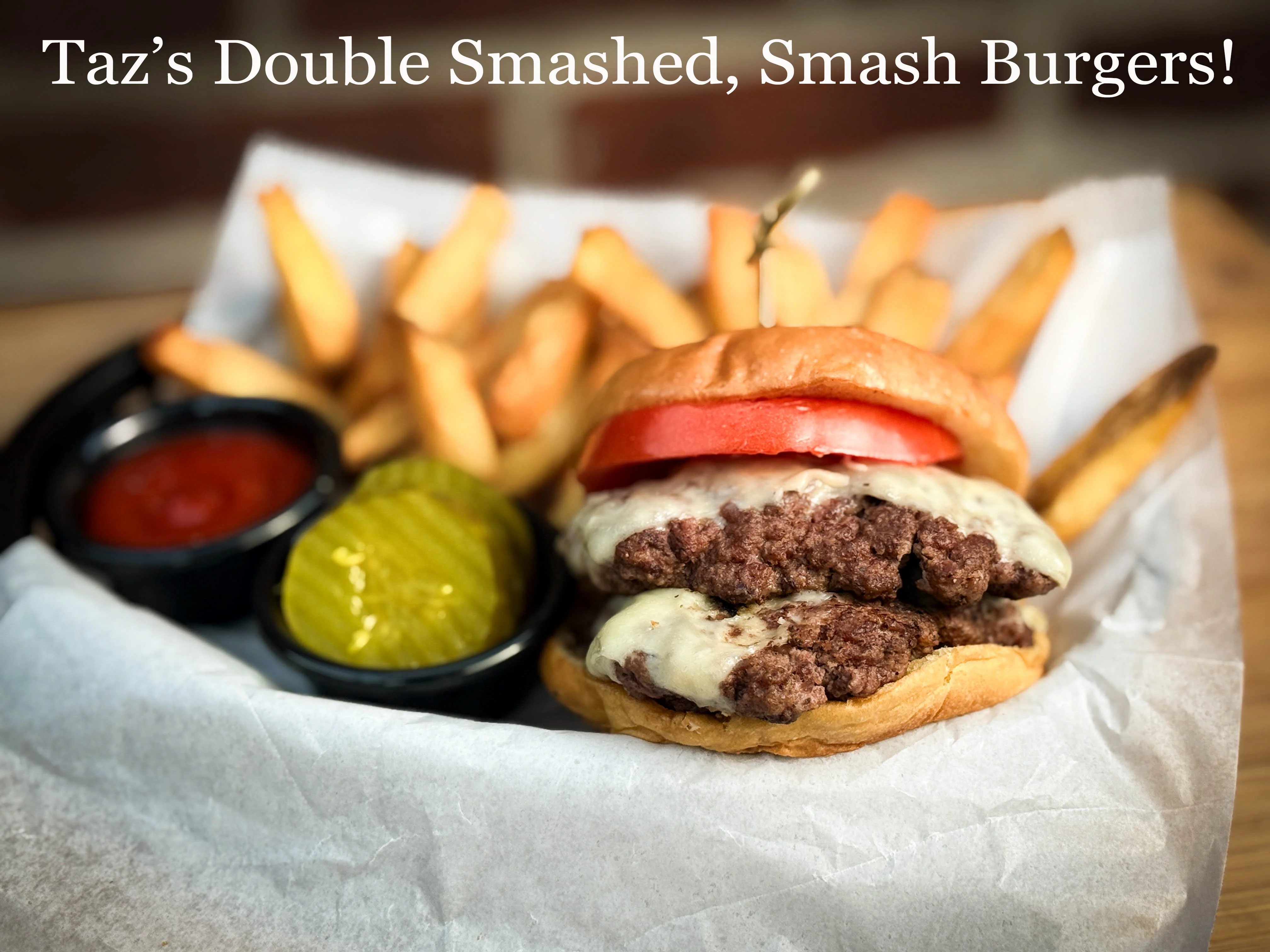 A double cheeseburger with melted cheese, tomatoes, pickles, and crispy fries on the side.