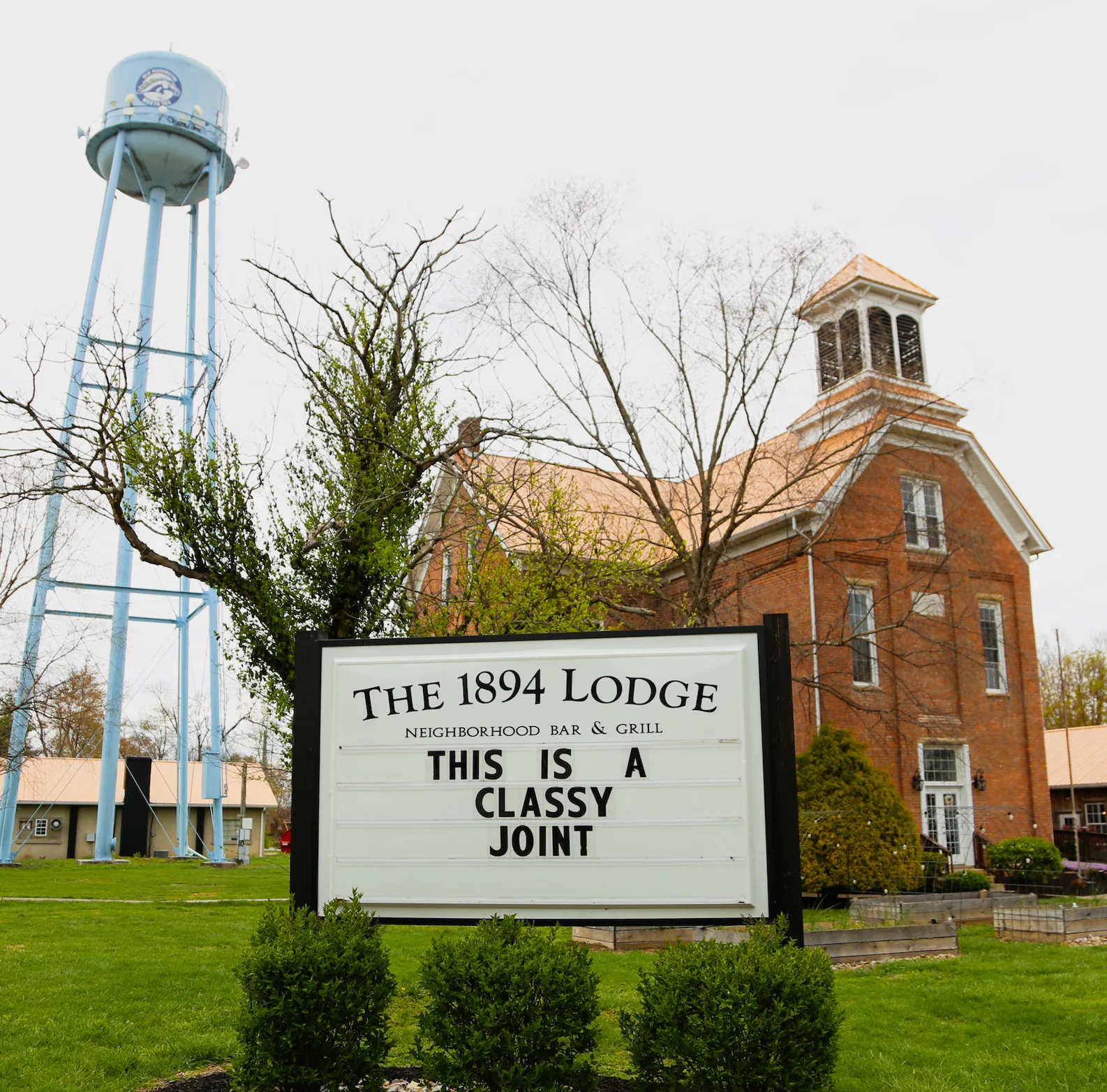 outside view of The Lodge, sign out front that says "this is a classy joint"