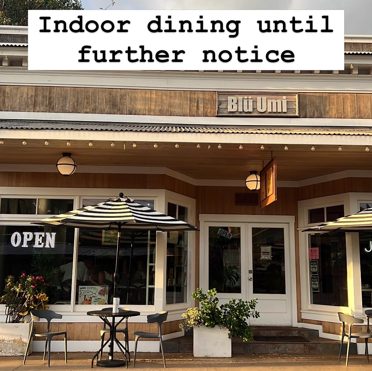 Charming restaurant exterior with open dining and striped umbrellas