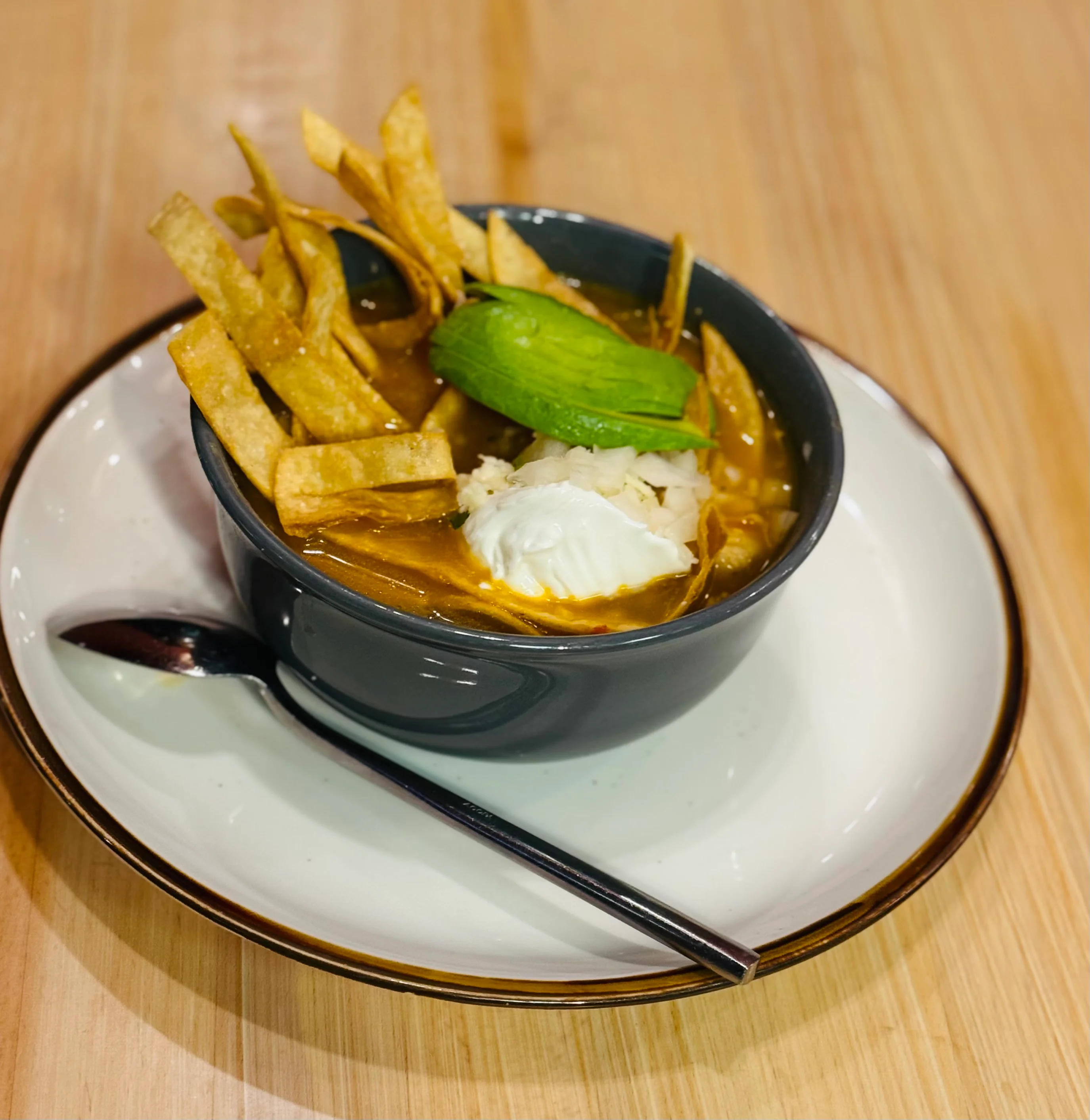 A colorful plate featuring shrimp fajitas with sautéed bell peppers and onions, served with Mexican rice and refried beans topped with cheese.