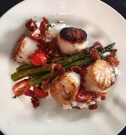 A modern plate presenting seared meat with asparagus, cherry tomatoes, and a balsamic drizzle for added flavor.