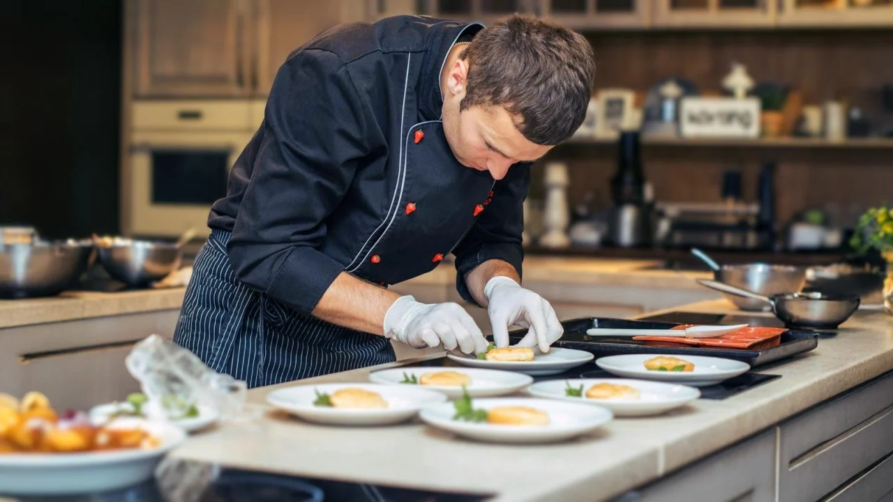 Chef plating gourmet dish in modern kitchen