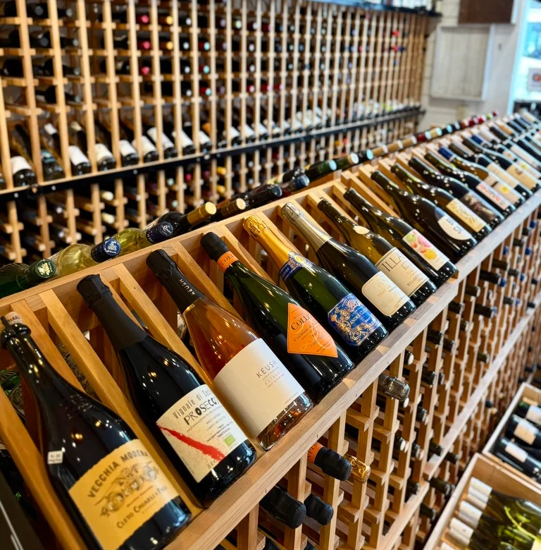 Wine bottles displayed in a wooden wine rack at a restaurant