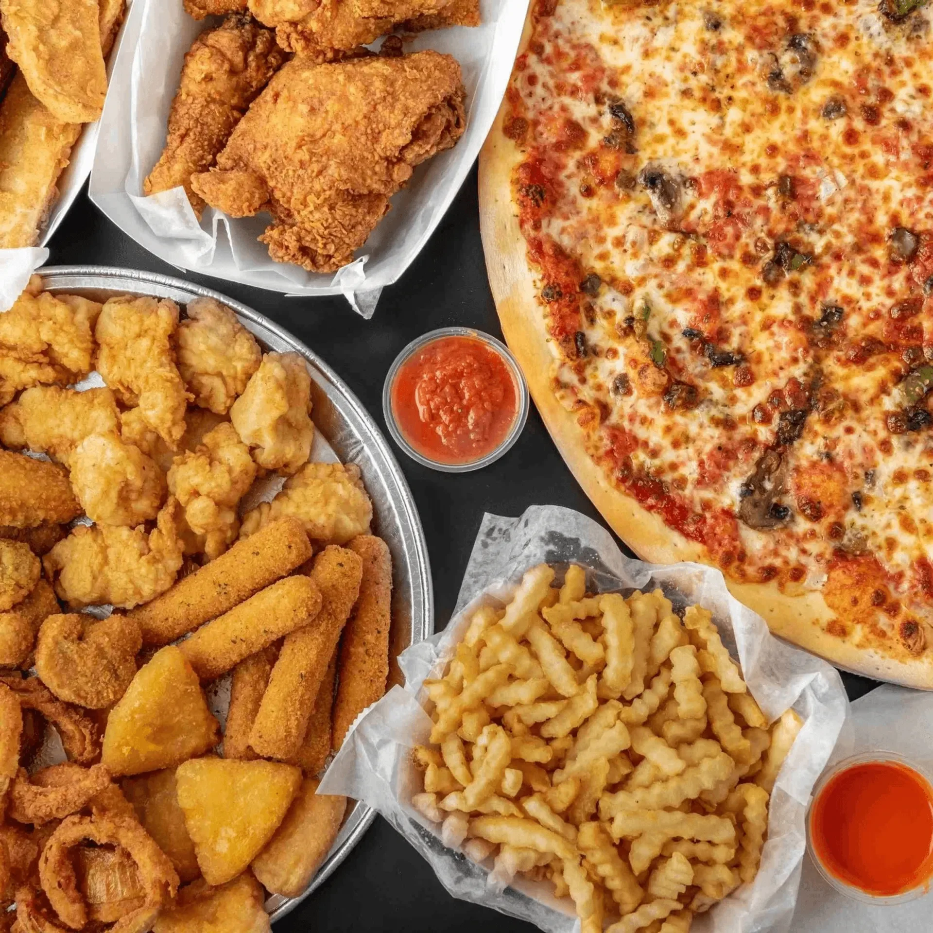 Assorted fried chicken and pizza platter with sides