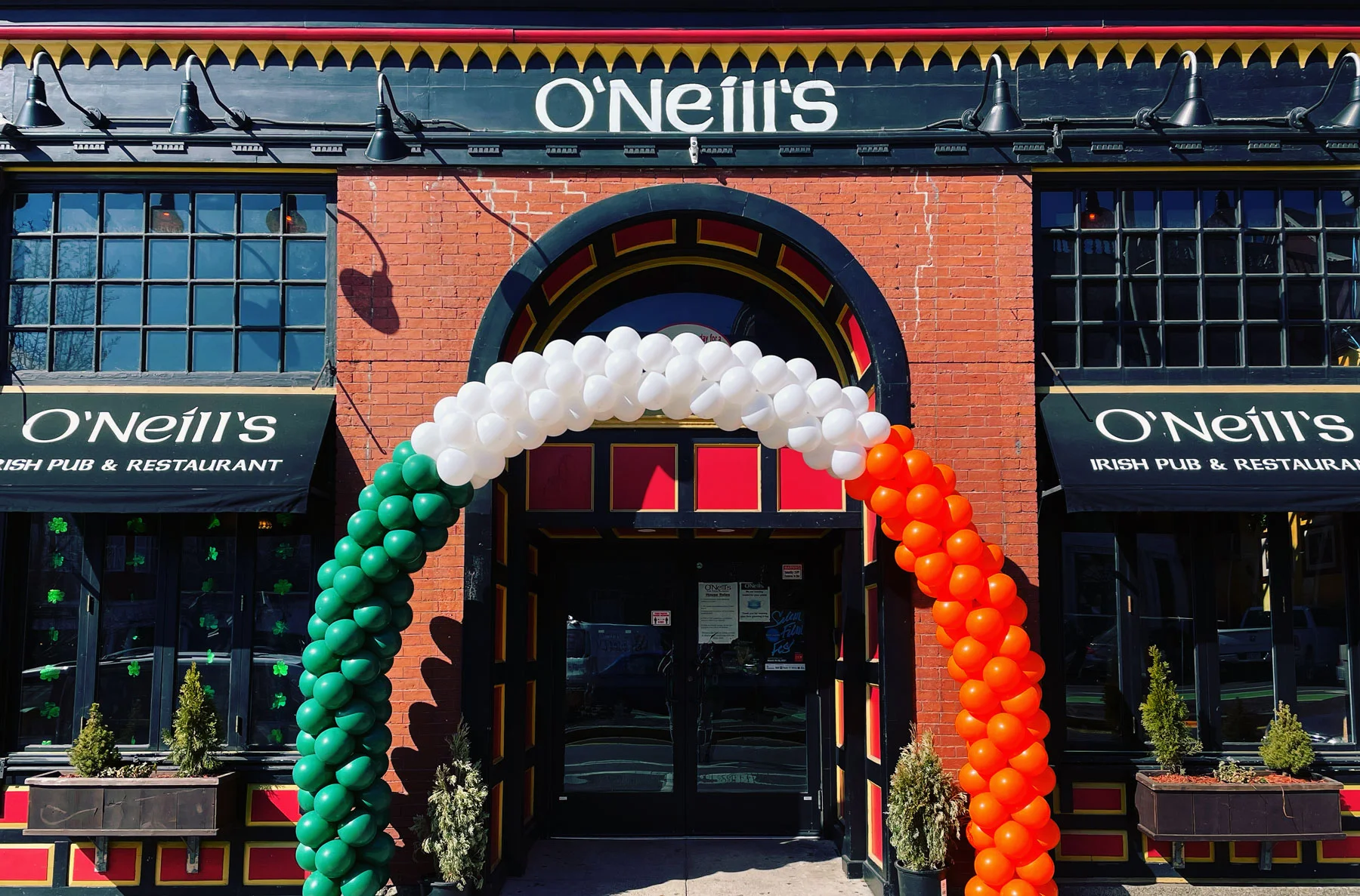 Exterior of O'Neill's Irish pub with festive balloon arch