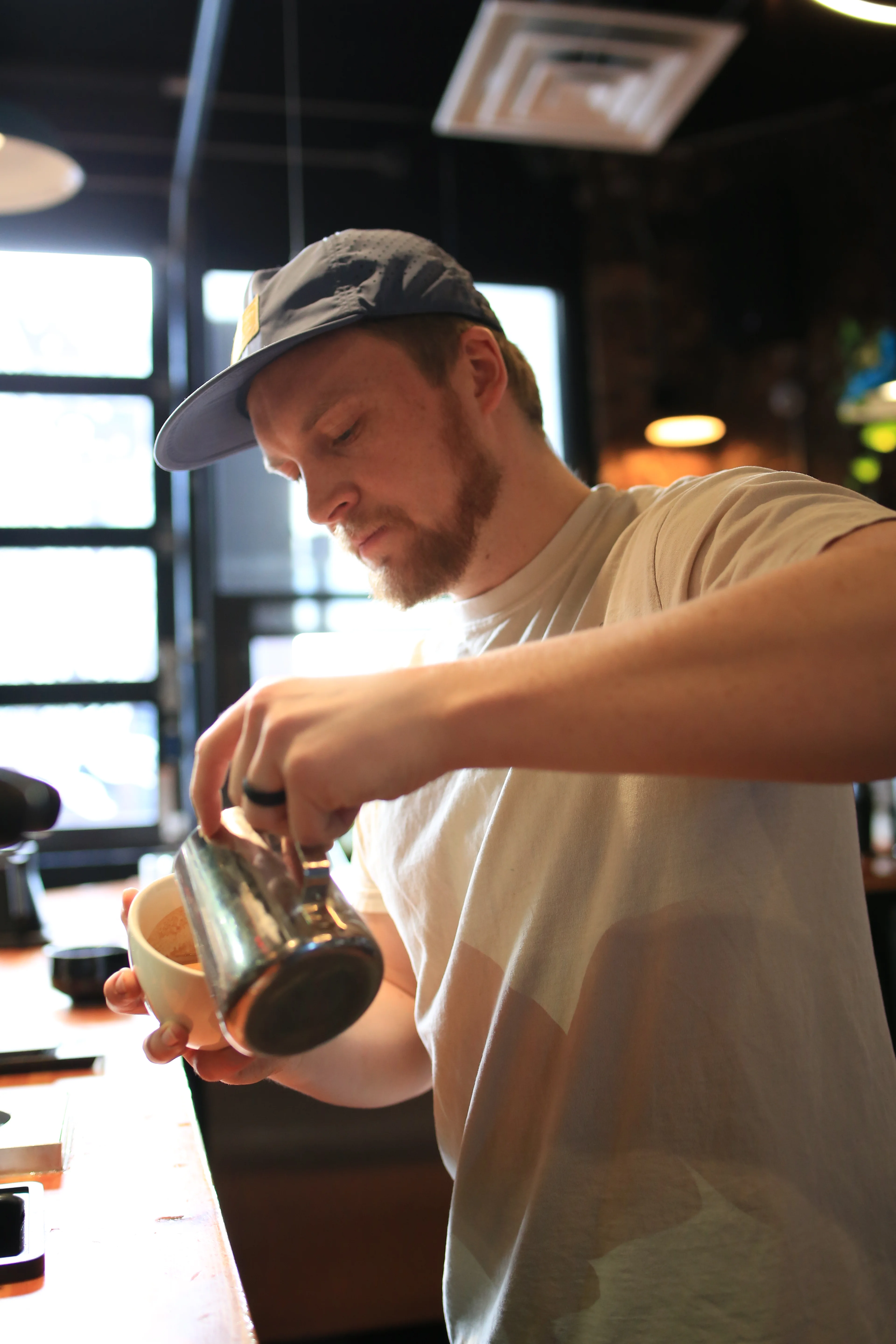 Barista pouring coffee at a modern café