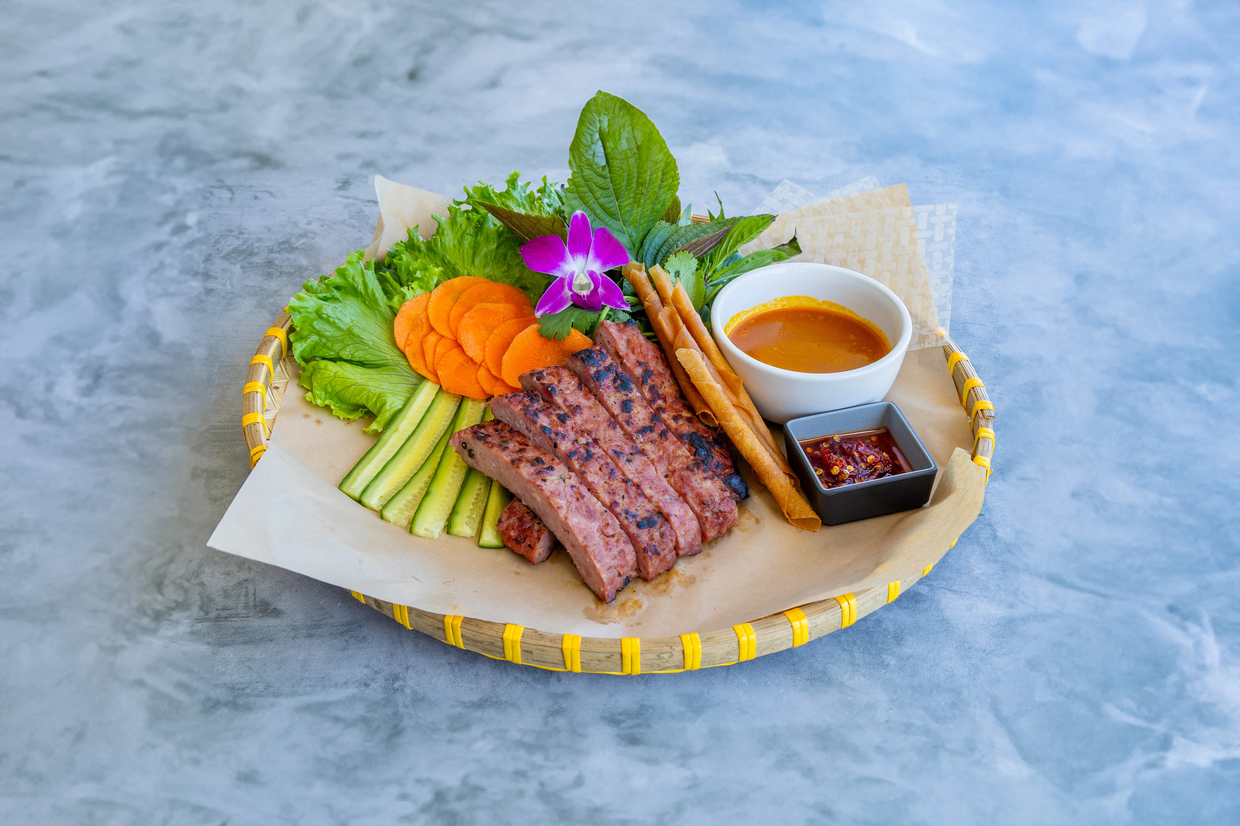 Vietnamese grilled beef platter with fresh herbs and dipping sauces