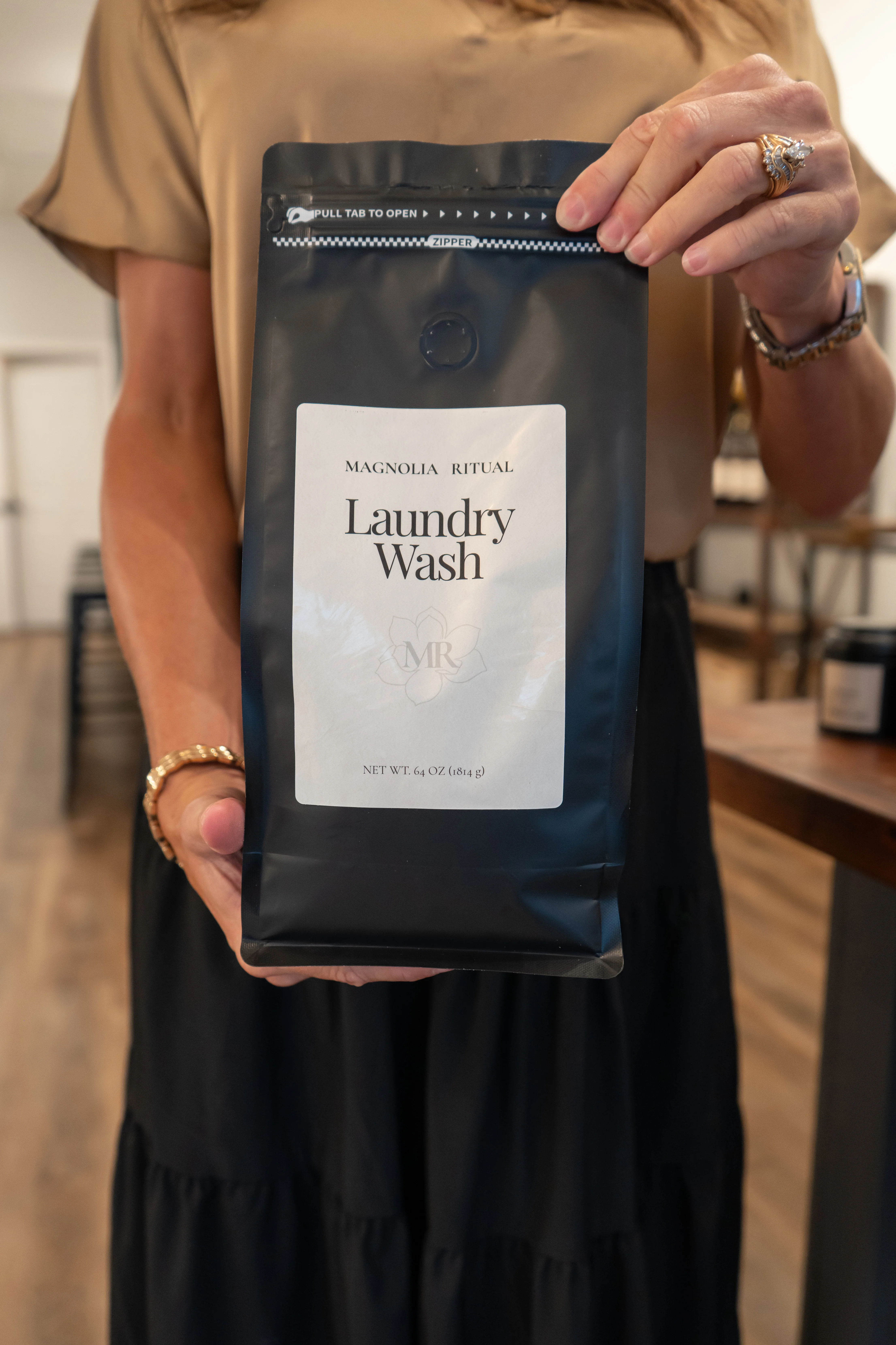 Customer holding a bag of Magnolia Ritual handcrafted Laundry Wash in the Magnolia, Texas shop.
