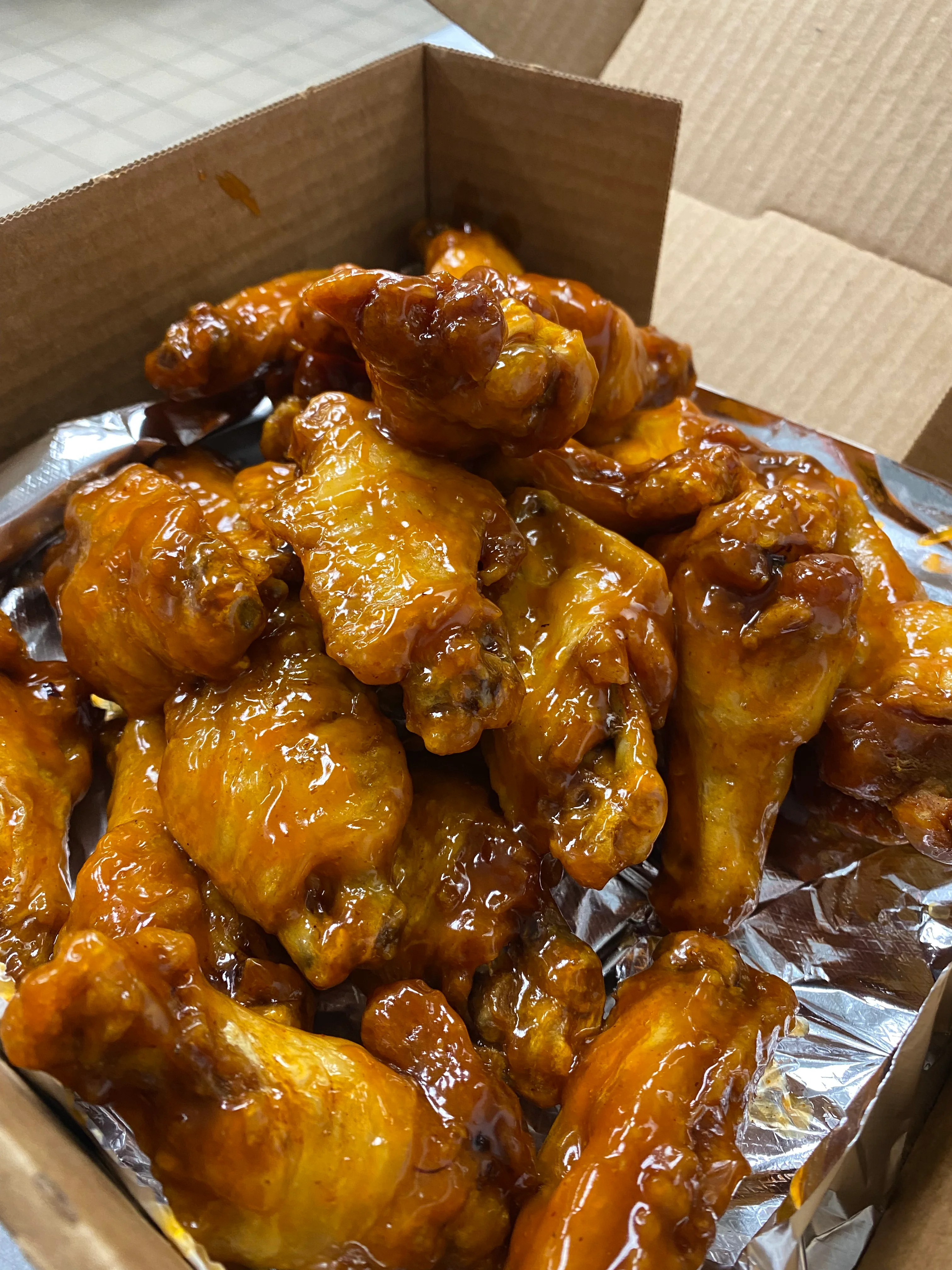 Crispy buffalo chicken wings in a takeout box