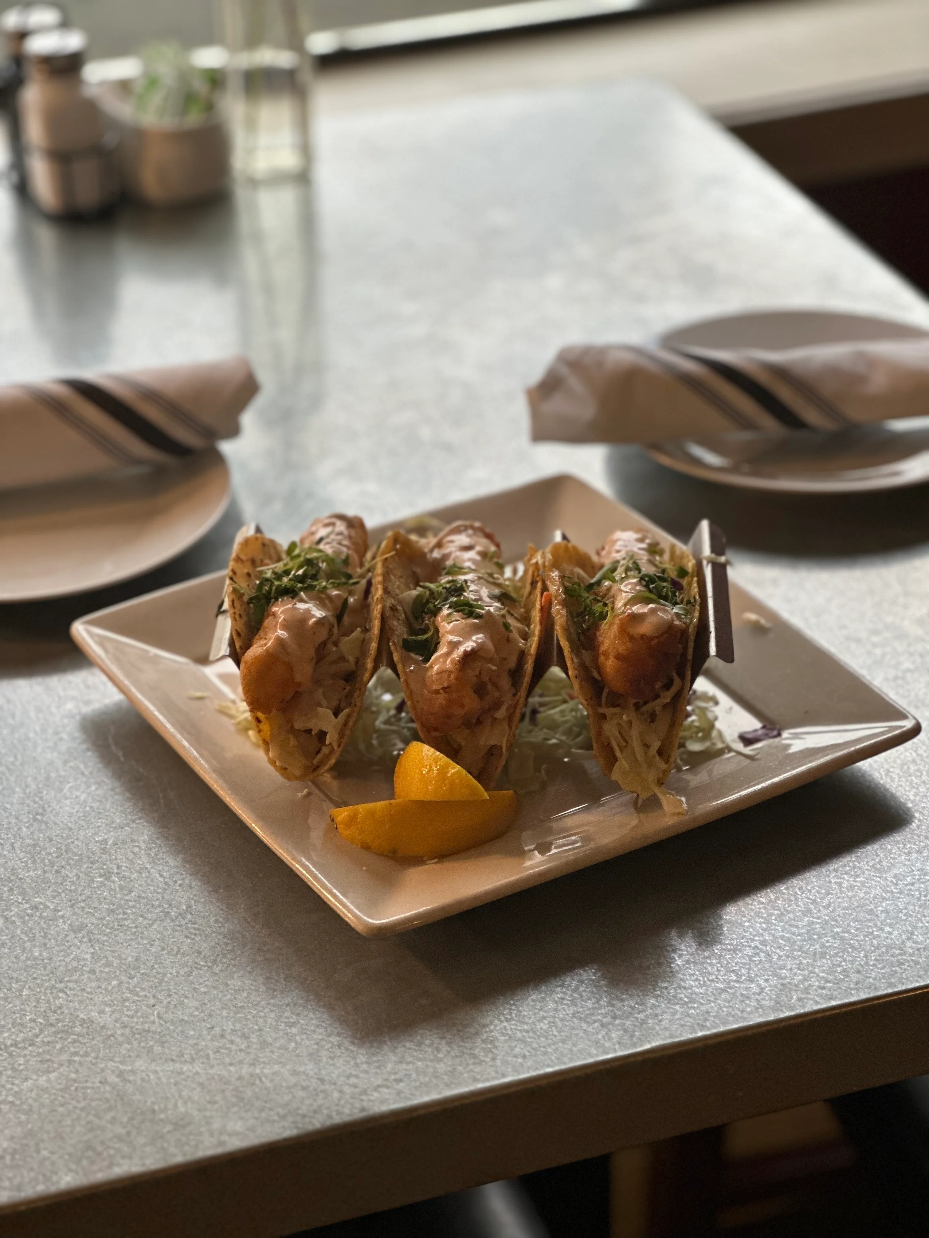 Crispy fish tacos served with lemon wedges