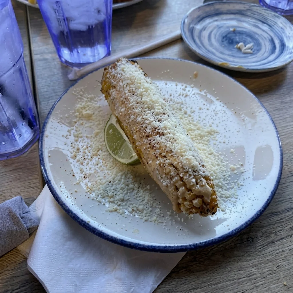 Mexican elote topped with cheese and lime