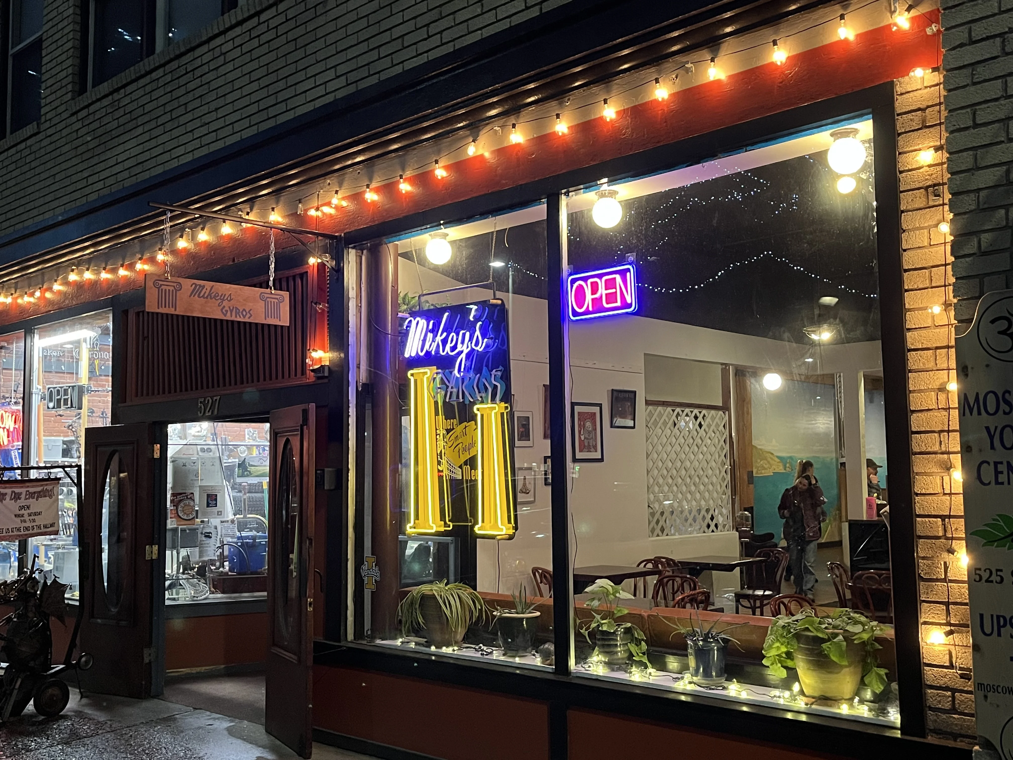 Cozy restaurant exterior with neon signs and warm lighting