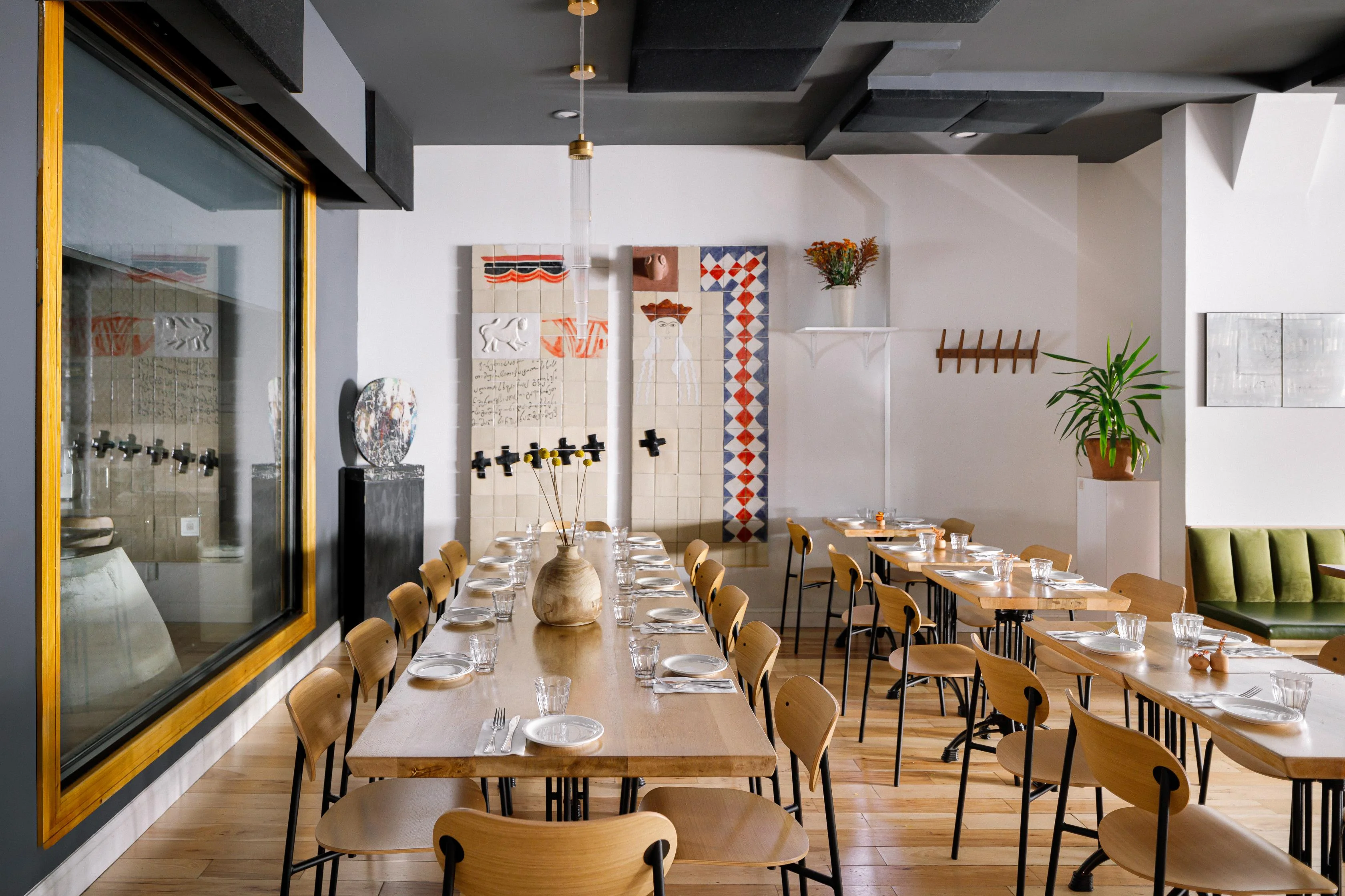 Modern restaurant interior with wooden tables and artistic decor