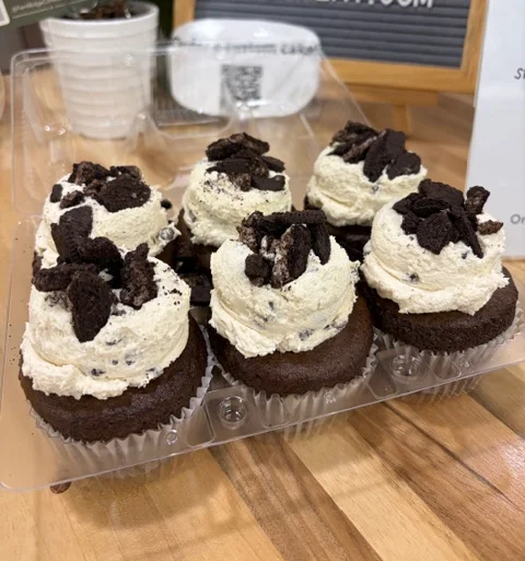 Assorted gourmet cupcakes in a clear container