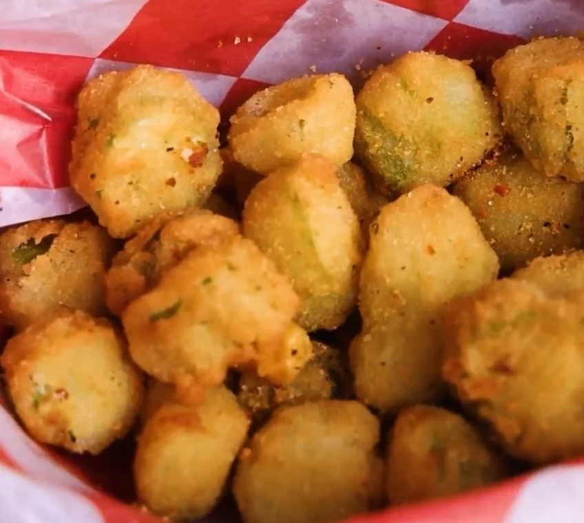 Crispy Southern fried okra bites served in red checkered paper
