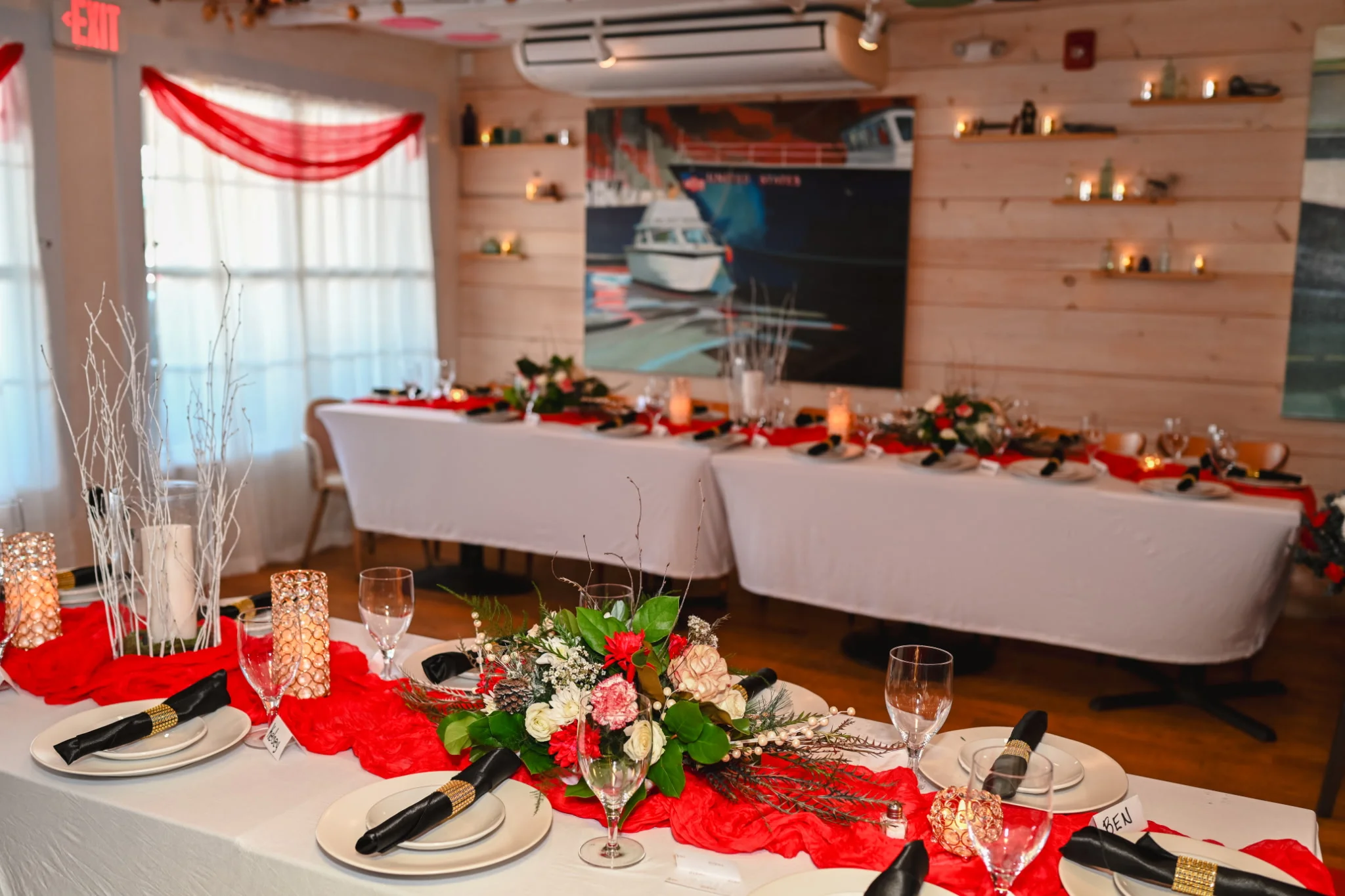 Elegant dining setup with floral arrangements and red accents.