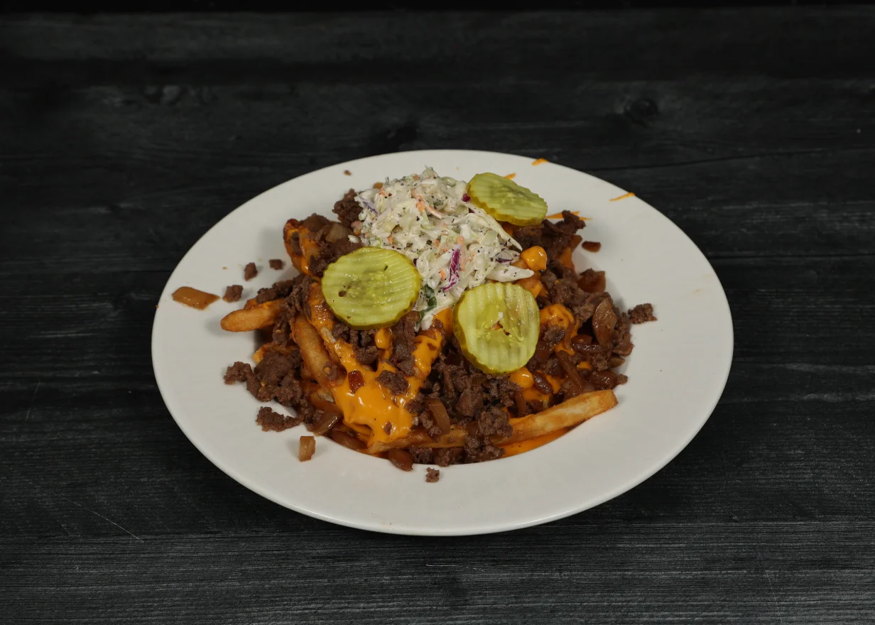 Delicious steak served with crispy cheese fries on a plate.