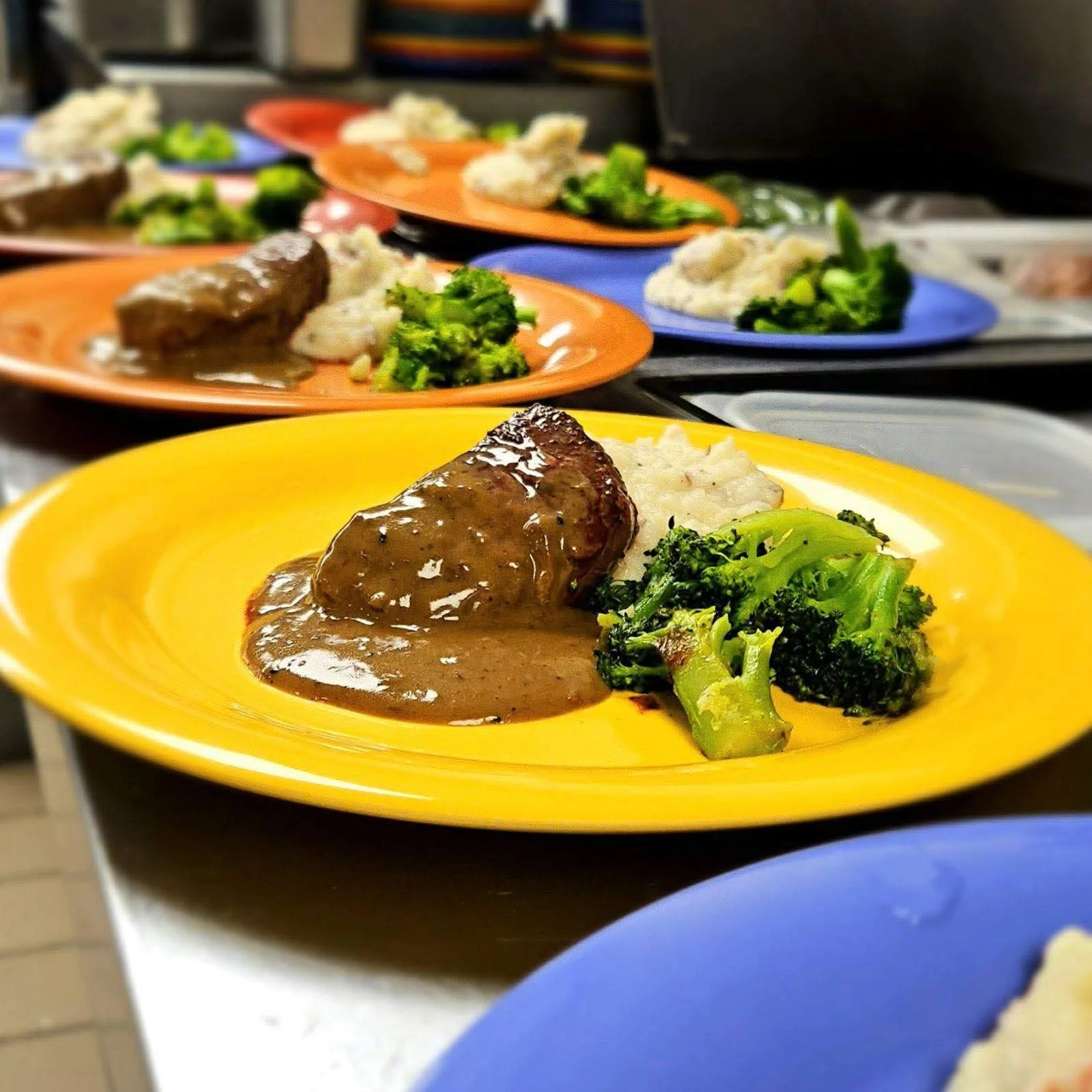 Savory meatloaf with gravy, broccoli, and rice on a colorful plate
