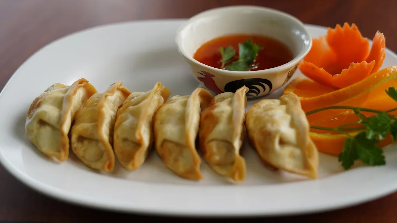 Plate of crispy Nepali momos with dipping sauce