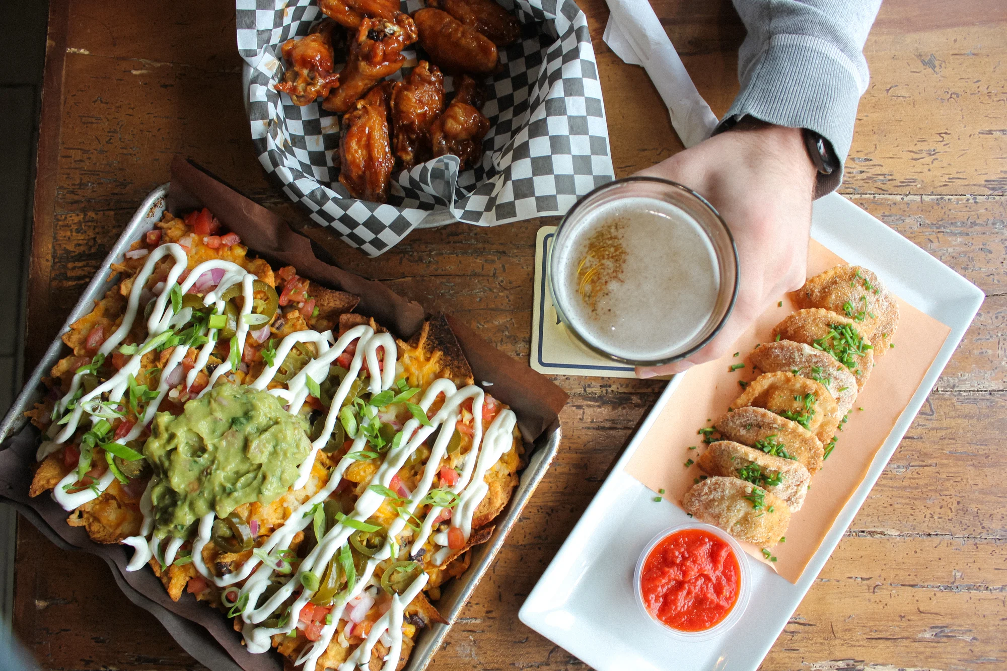 Loaded nachos with guacamole and beer in a casual dining setting