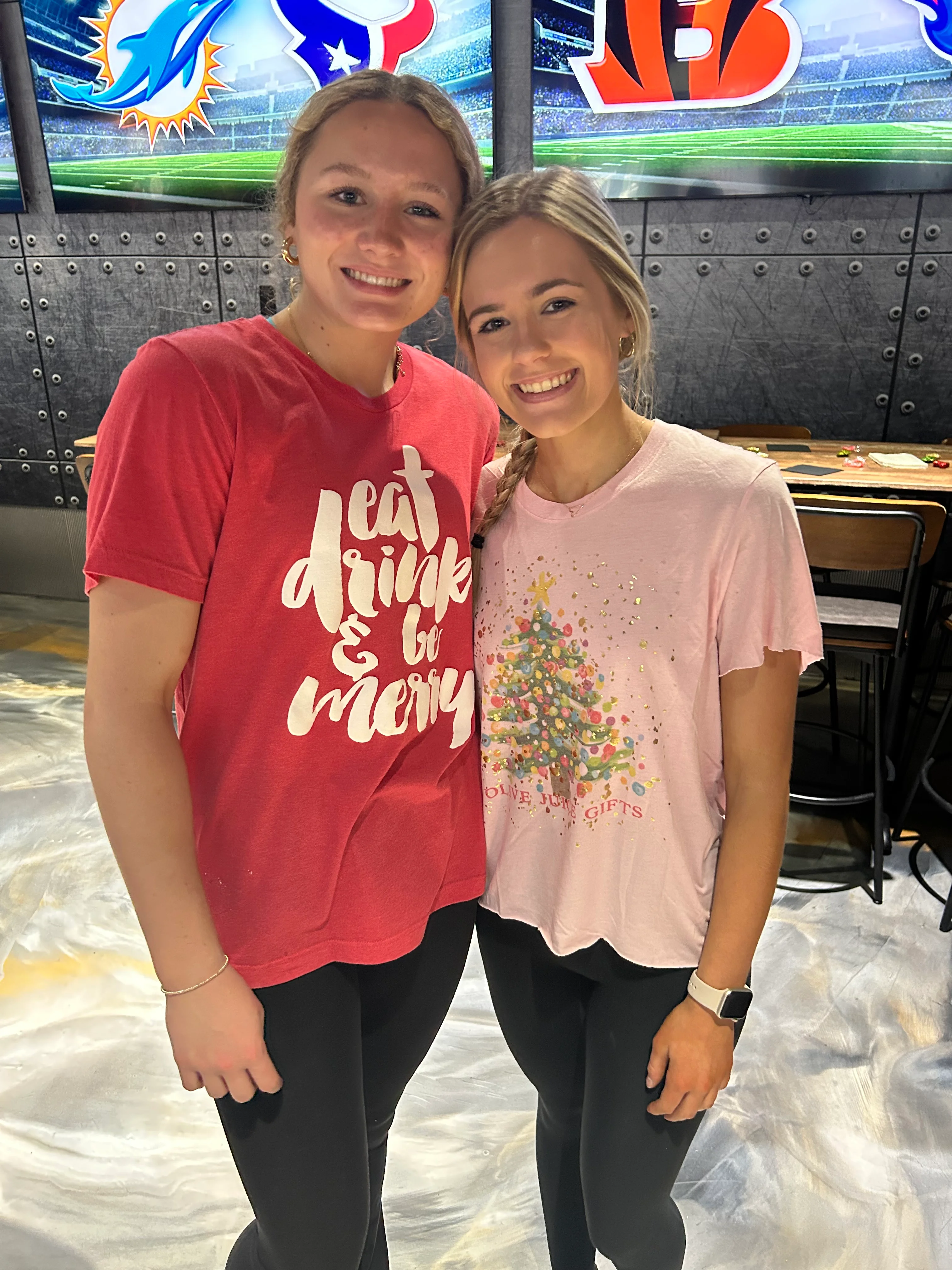 Two friends smiling in a sports bar setting