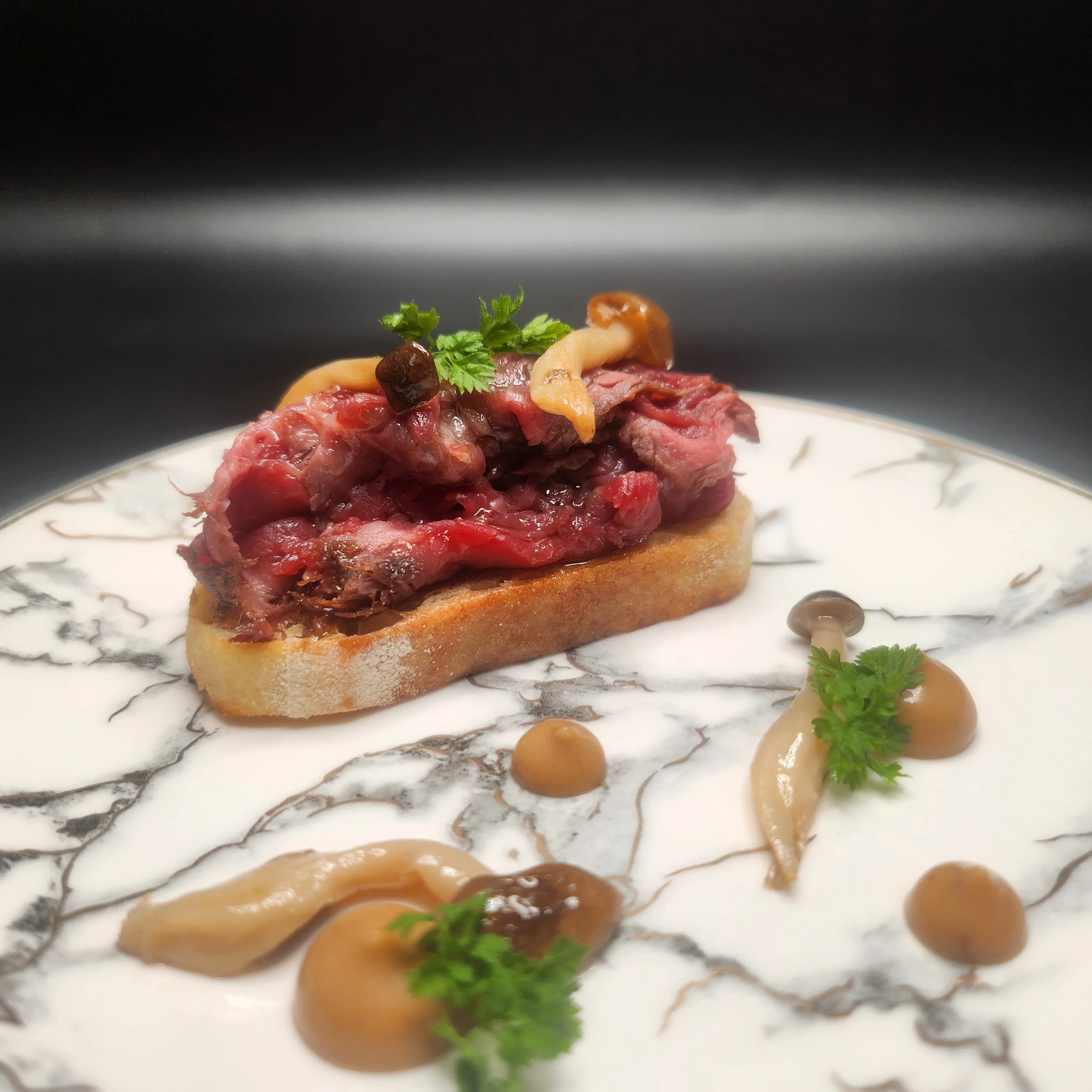Plate of Wagyu Carpaccio garnished with herbs and spices.