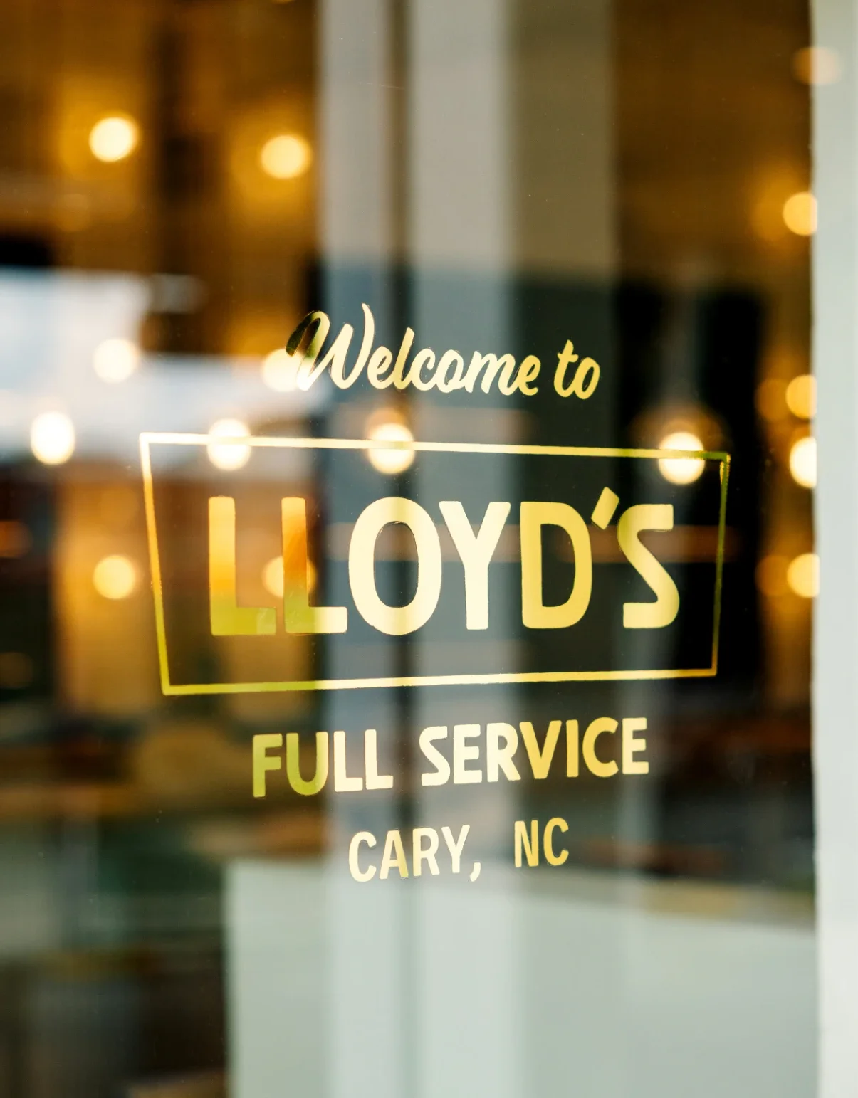 Welcome to Lloyd's Full Service in a reflective, gold leaf sign, handpainted on the front door to the restaurant