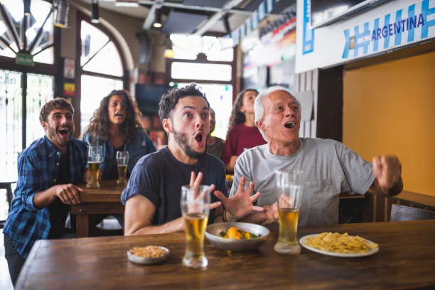 Excited patrons enjoying food and drinks in a lively restaurant atmosphere