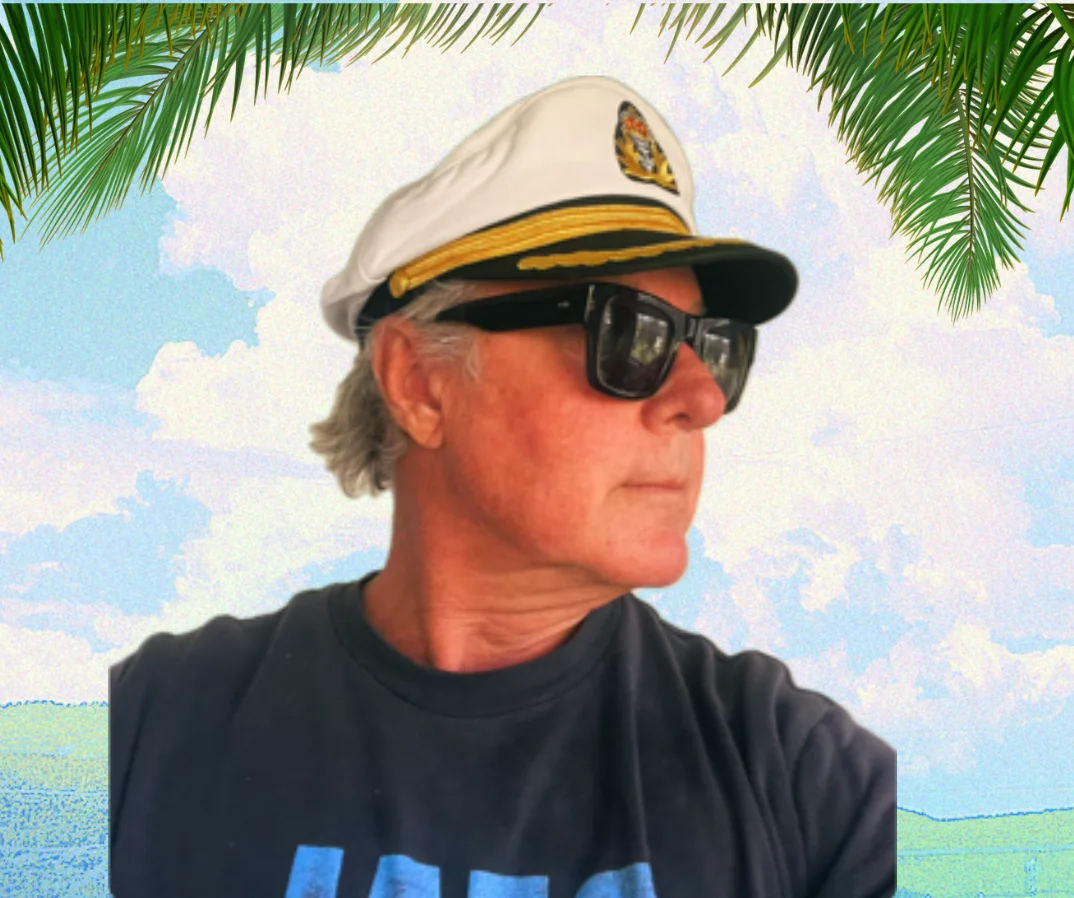Man in a captain's hat with sunglasses against a tropical background