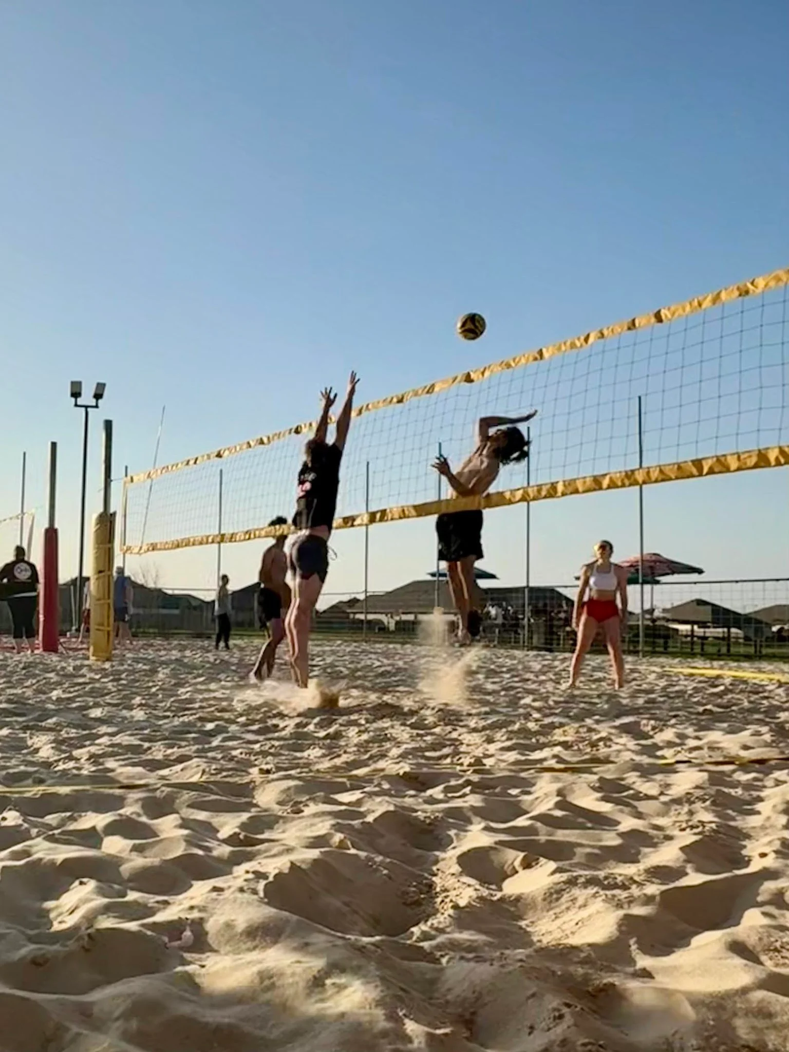 A volleyball game in action with players on the court.