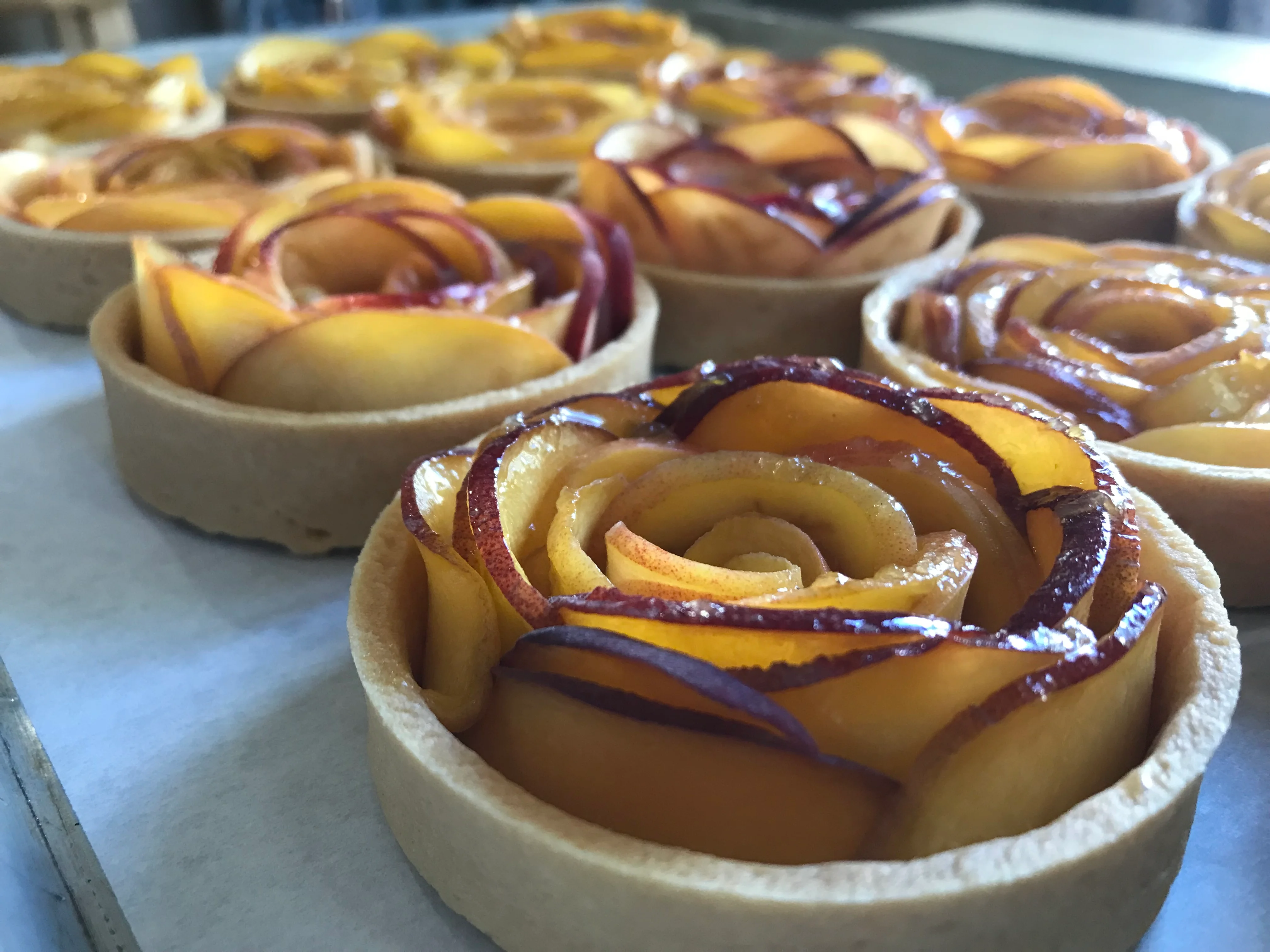 Beautiful peach tart with rose-shaped fruit arrangement