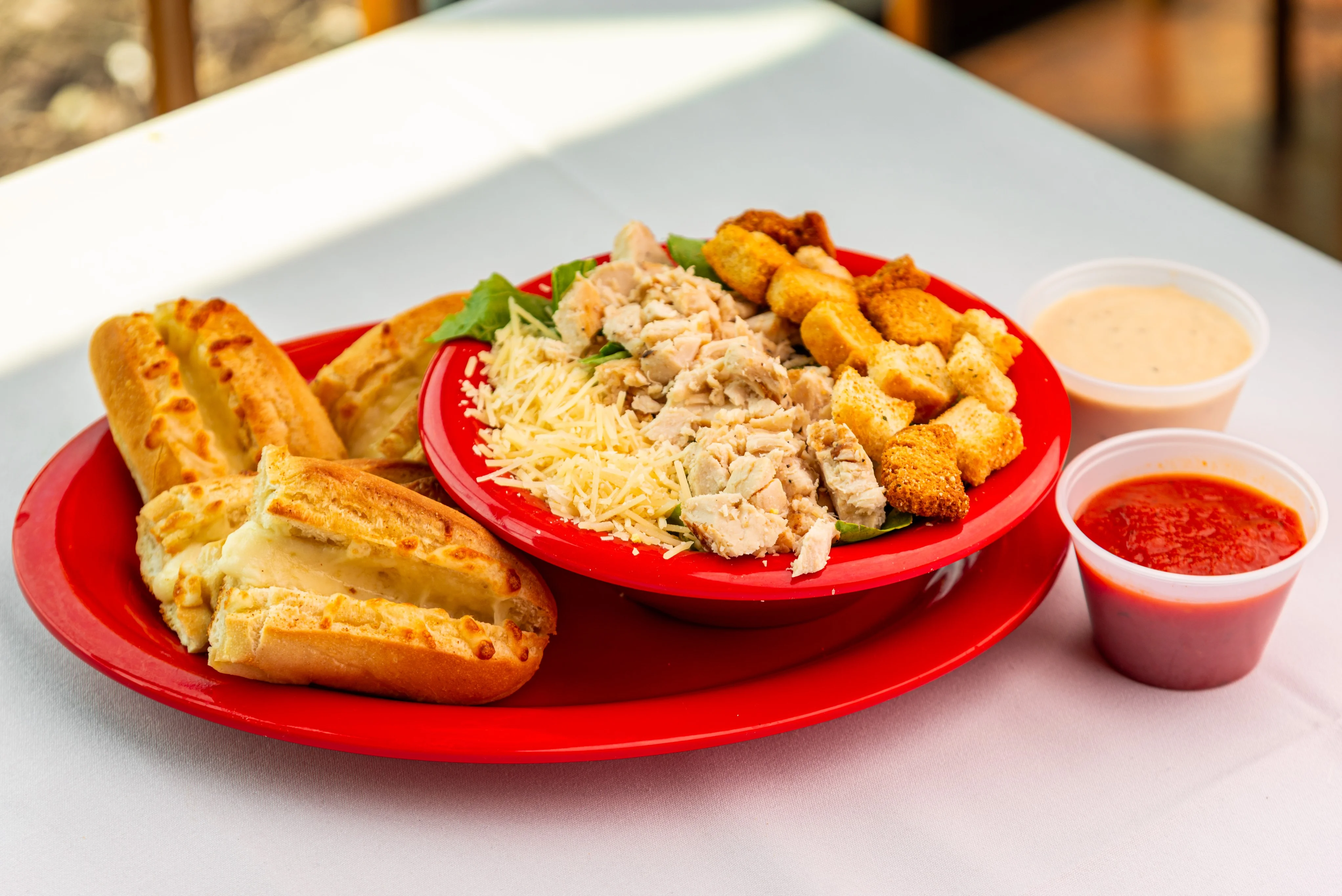 Grilled chicken Caesar salad with cheesy breadsticks