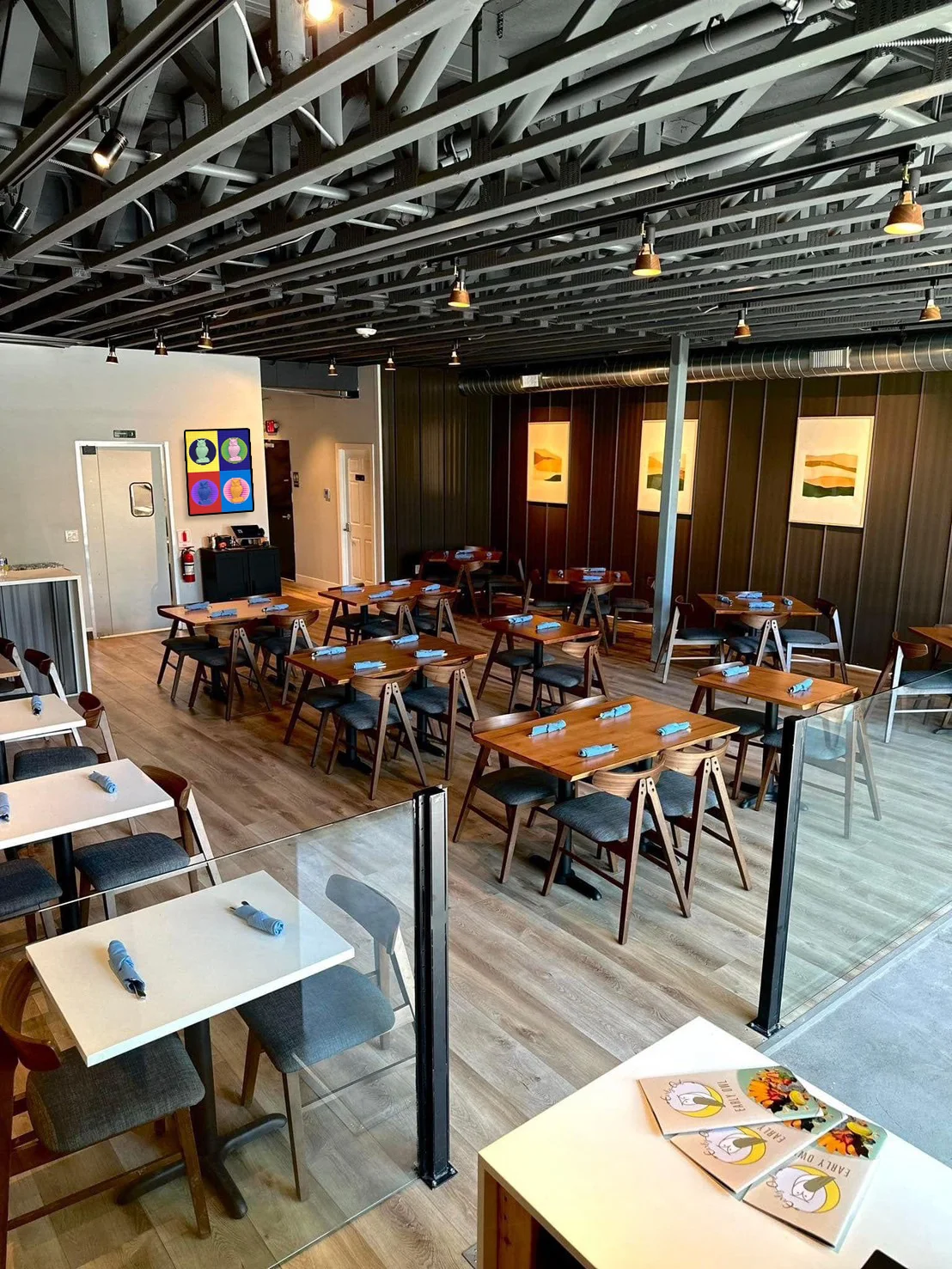 Modern restaurant interior with wooden tables and artistic decor
